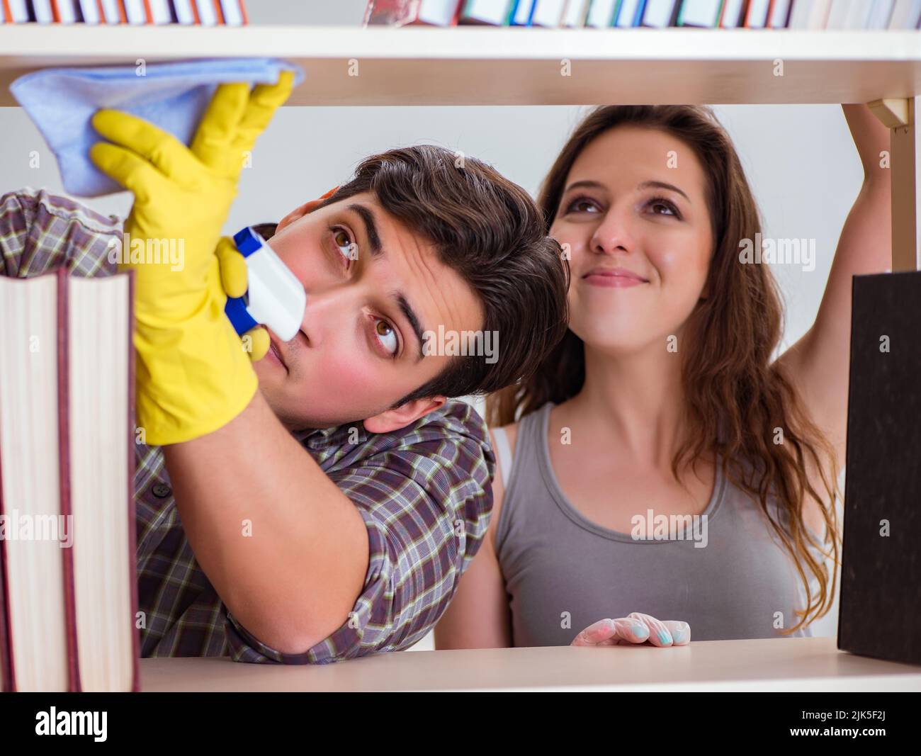 The wife and husband cleaning dust from bookshelf Stock Photo Alamy