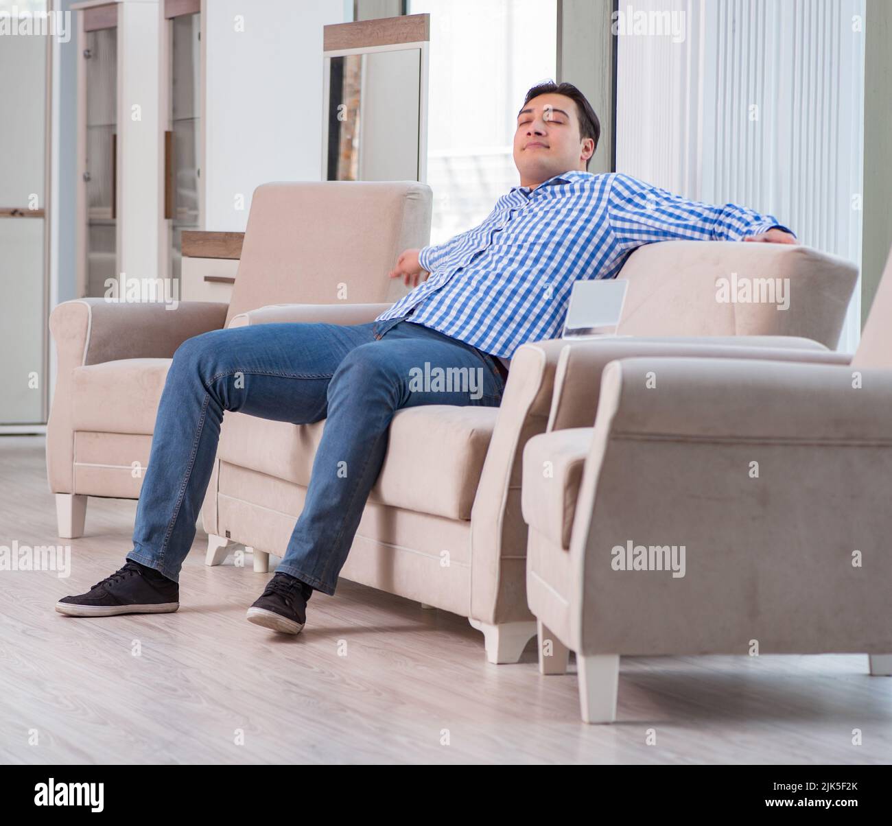 The young man shopping in furniture store Stock Photo - Alamy