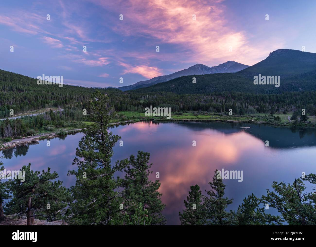 A pastel sunset reflects in Lily Lake above Longs Peak in Rocky Mountain National Park, Colorado Stock Photo