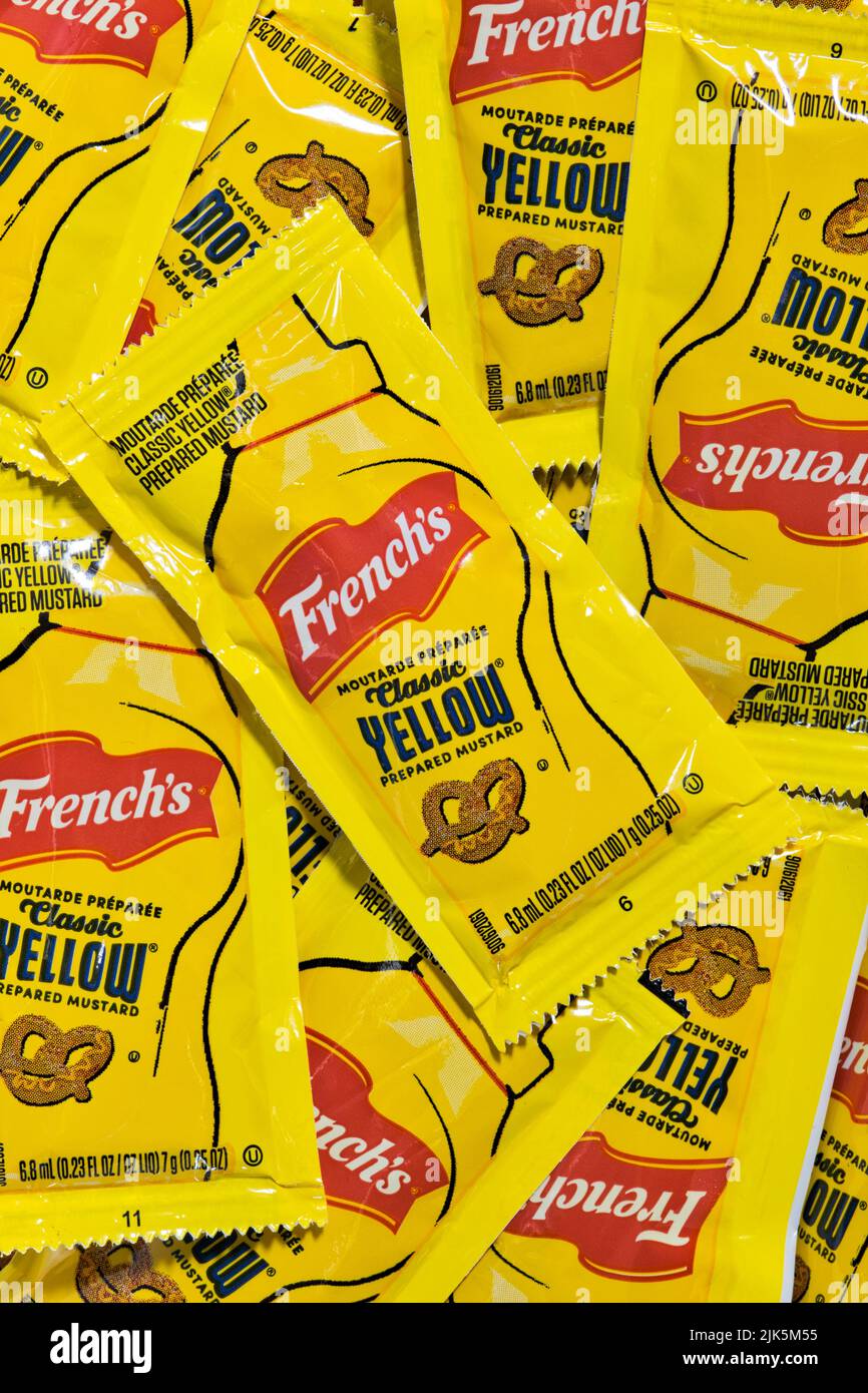 Houston, Texas USA 07-14-2022: French's Yellow Mustard sachets scattered loosely showing brand name and logo. American condiment owned by McCormick. Stock Photo