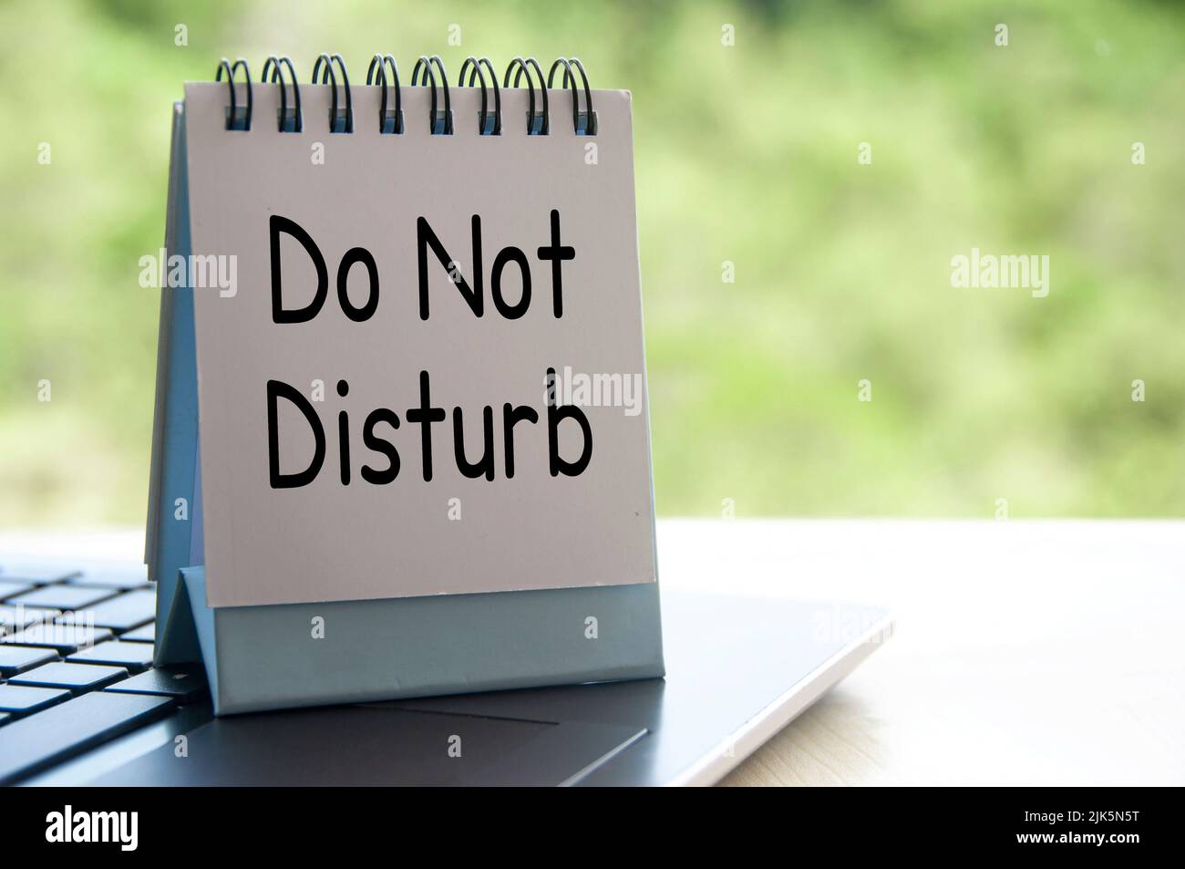 Do not disturb text on white table calendar on laptop keyboard. Stock Photo
