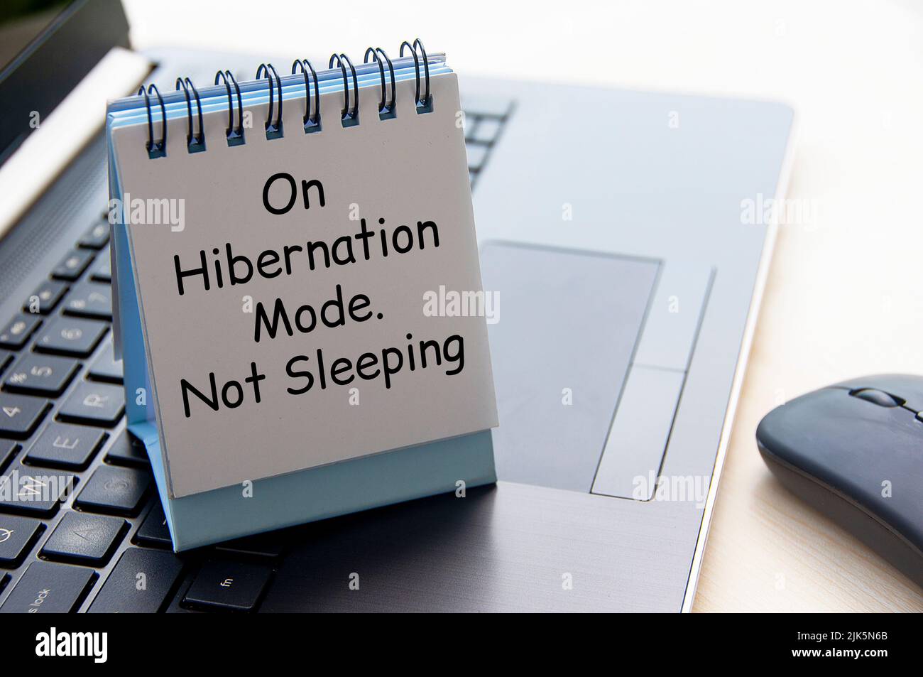 On hibernation mode. Not sleeping text on white table calendar on laptop keyboard. Laziness concept Stock Photo