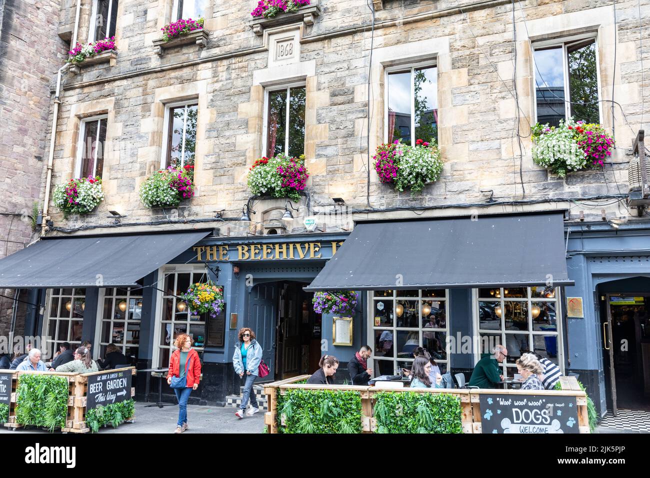 Grassmarket Edinburgh, The Beehive Inn public house, summers day with people drinking outside and flowering hanging baskets,Scotland,UK 2022 Stock Photo