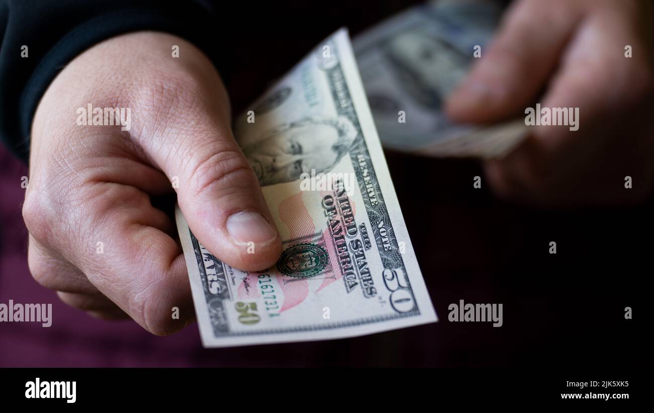 Fifty dollar bill in white male hand closeup Stock Photo