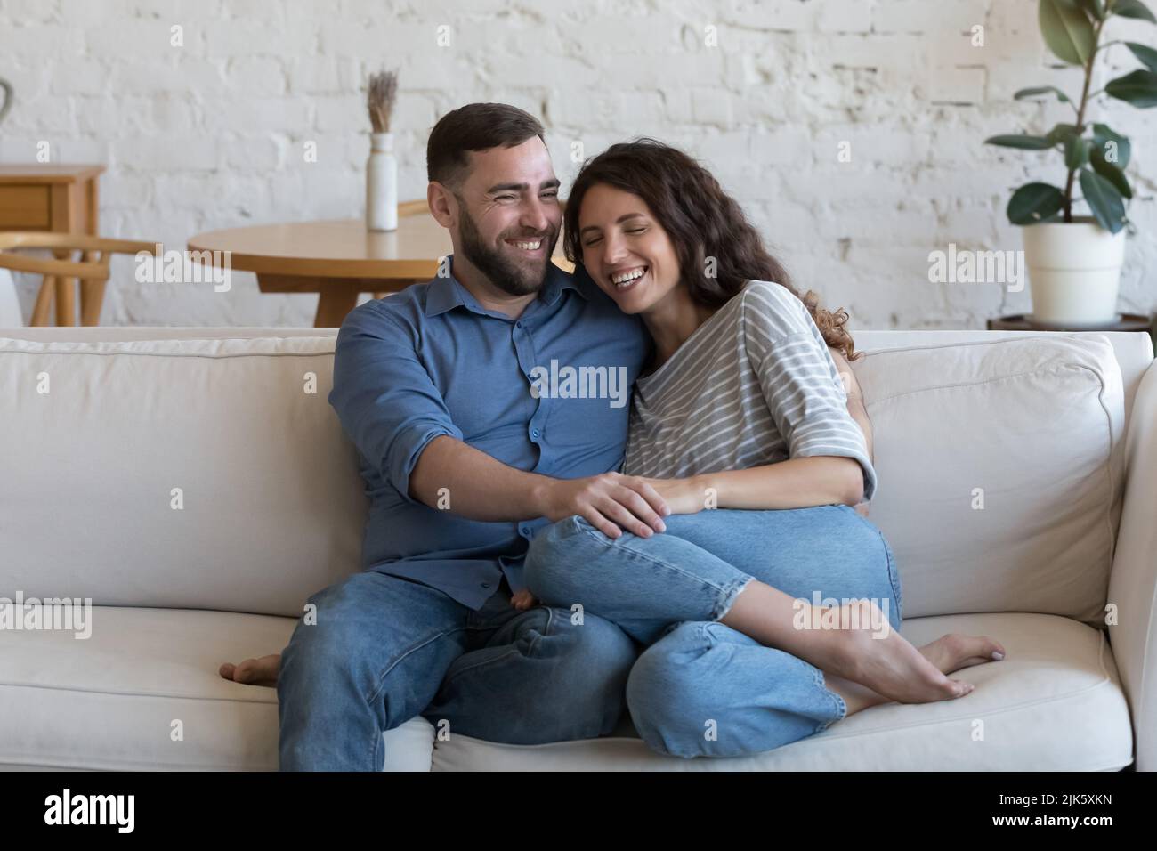 Cheerful dating couple in love enjoying being at home together Stock Photo