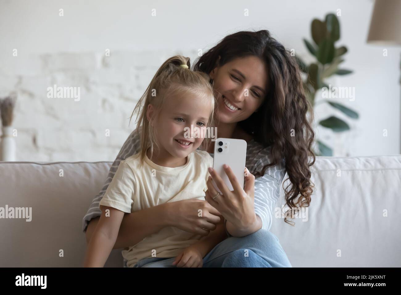 Happy mom holding cute little daughter kid in arms Stock Photo - Alamy