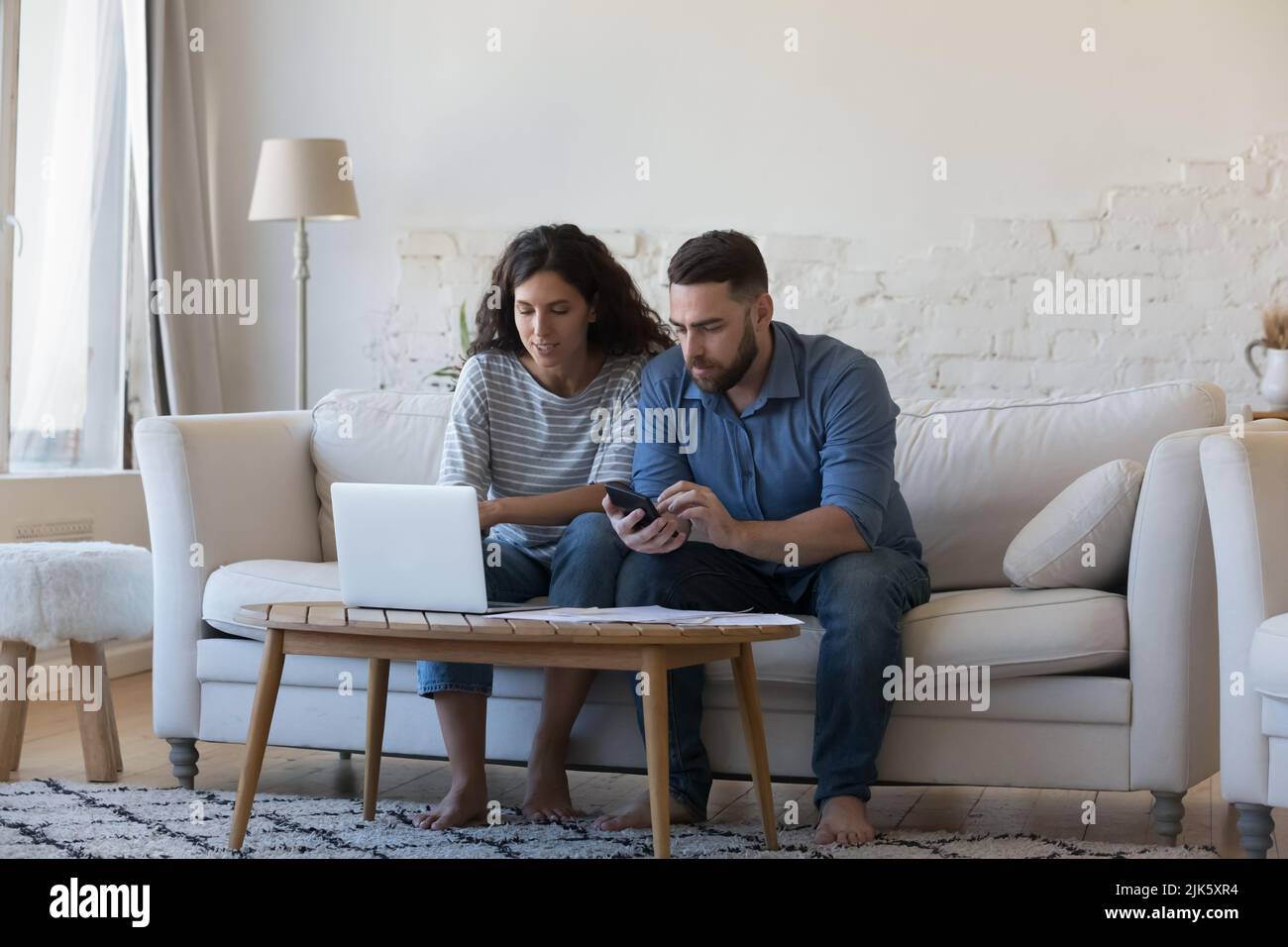 Focused married couple doing paperwork, accounting job at home Stock