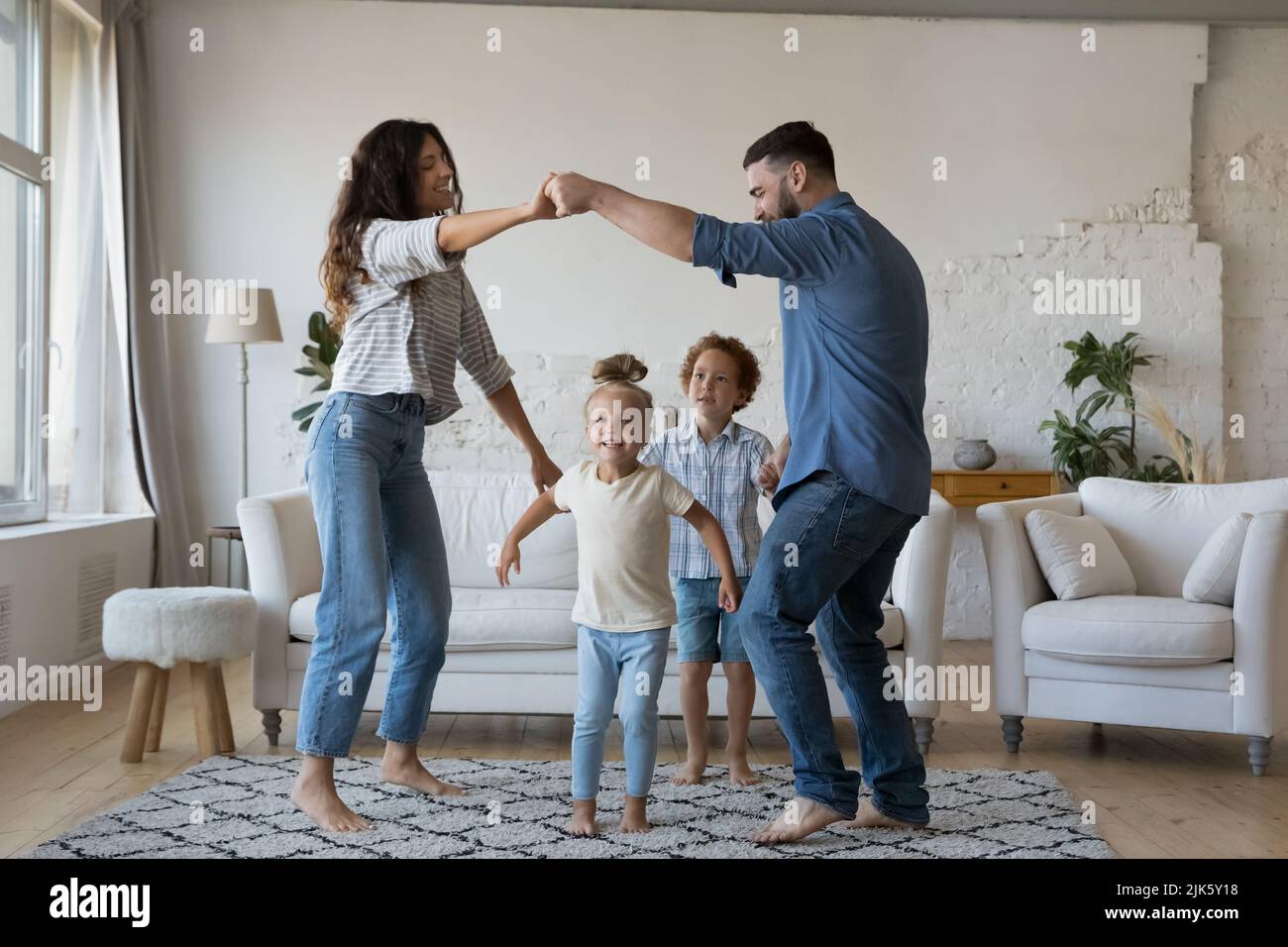 Happy active young parents and little kids playing active games Stock Photo