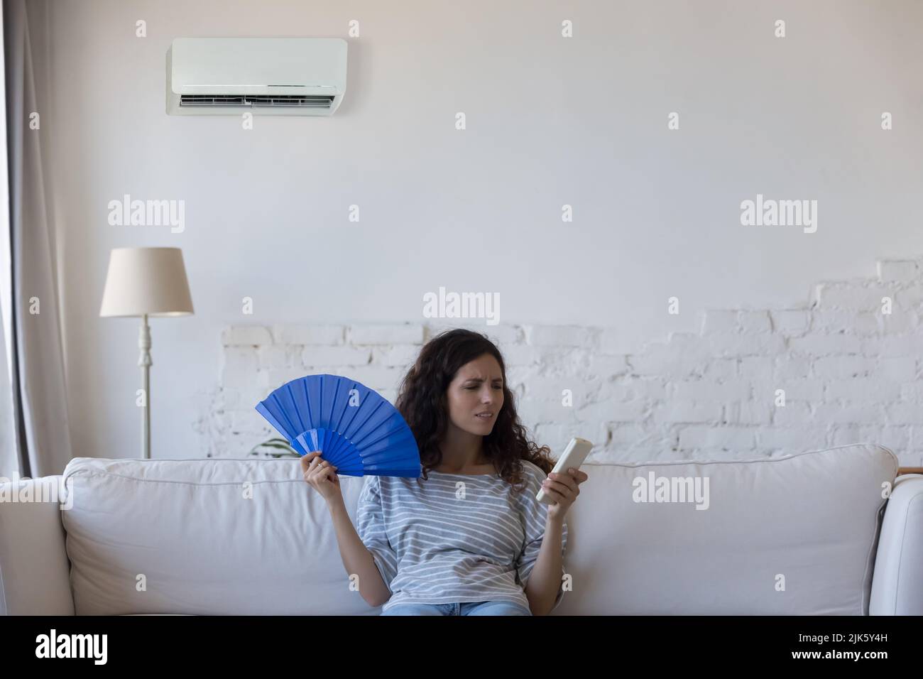 Annoyed homeowner young woman frustrated with heat Stock Photo