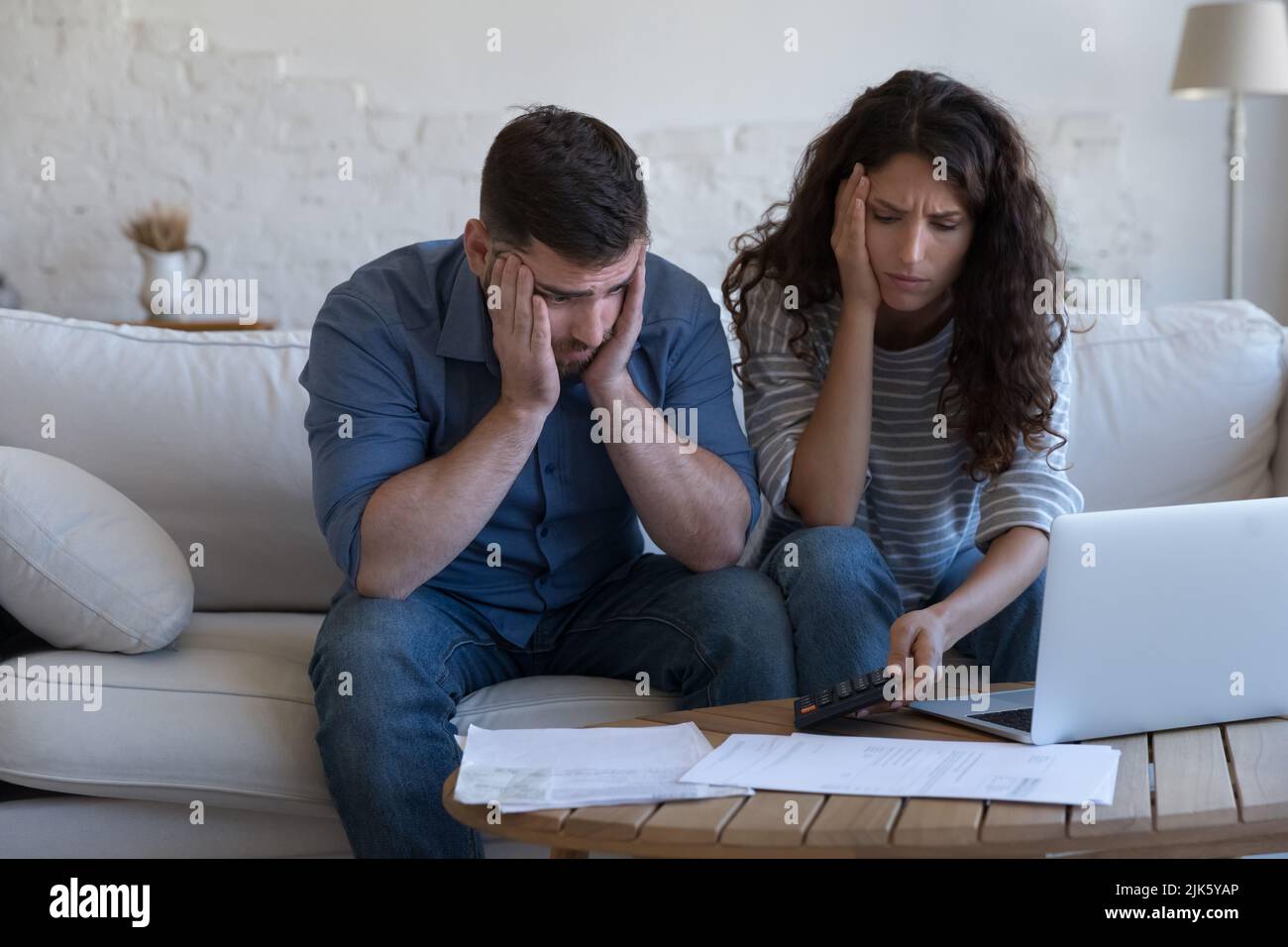 Concerned upset millennial couple counting overspent budget Stock Photo