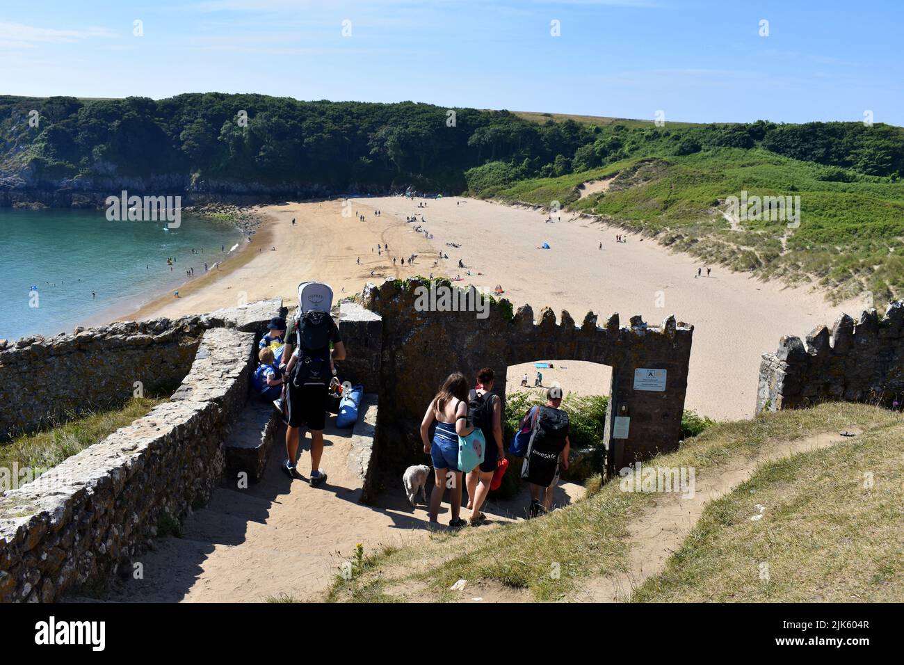 Tourists arriving at the walled entrance to Barafundle Bay, Stackpole, Pembrokeshire, Wales Stock Photo