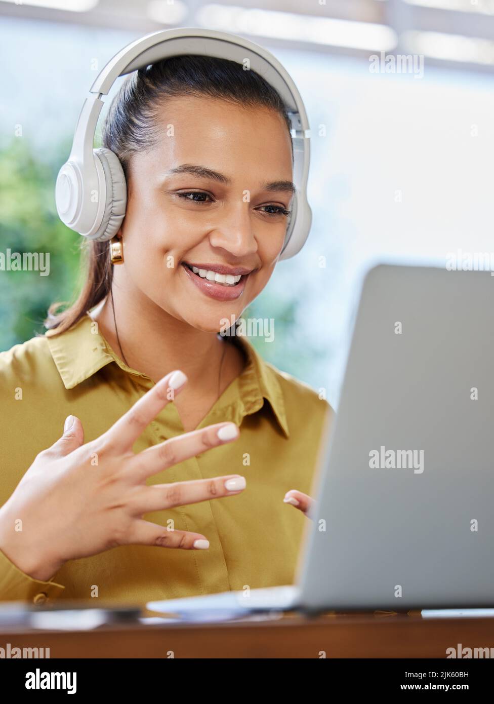 Conducting her meetings from home. an attractive young businesswoman using her laptop to have an online meeting at home. Stock Photo