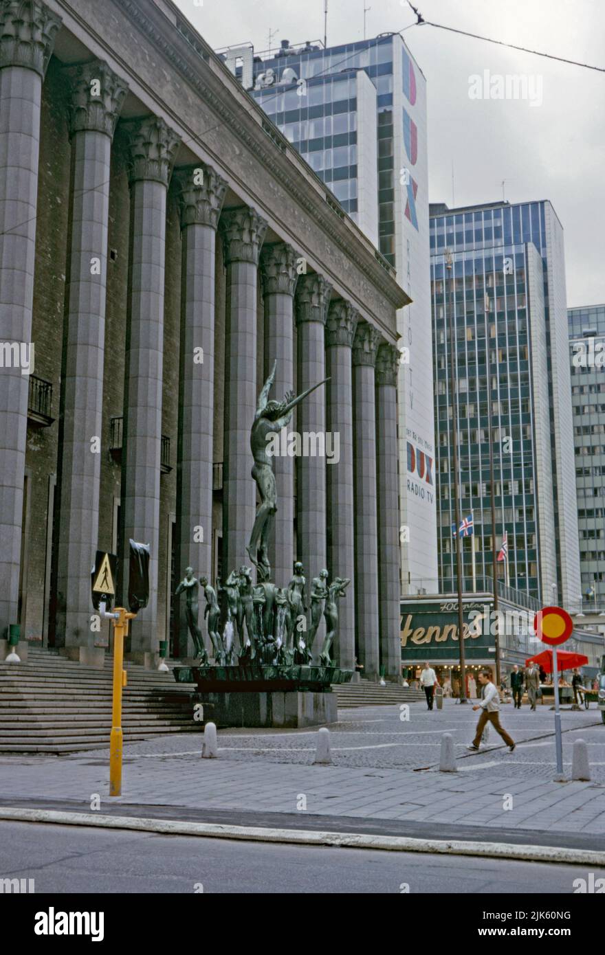 A view of the Konserthuset (Consert House) in the central Norrmalm district, Stockholm, Sweden in 1970. The sculpture is The Orpheus Group, by Carl Milles. In the background are the Hötorget buildings, five modernist high-rise office blocks. The nearest block carries a giant advertising logo for Dux TVs and radios. Norrmalm is at centre of Stockholm. This image is from an amateur 35mm colour transparency – a vintage 1970s photograph. Stock Photo