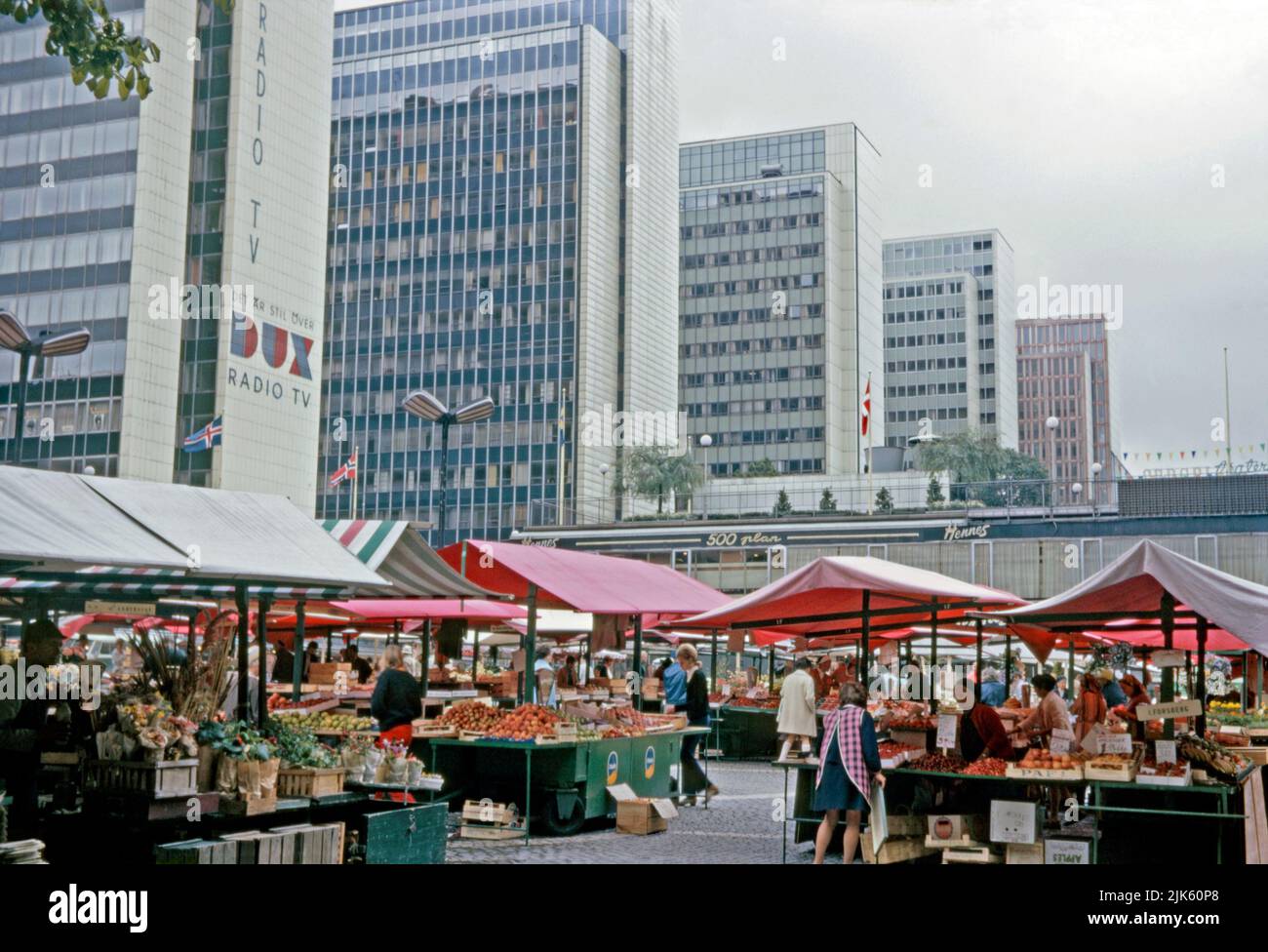 A view of the Hötorget buildings (Hötorgshusen or Hötorgsskraporna) in the central Norrmalm district, Stockholm, Sweden in 1970. In the foreground is the Hötorget torghandel (market) outside the Konserthuset (Consert House). The Hötorget buildings are five modernist high-rise office blocks. The nearest block carries a giant advertising logo for Dux TVs and radios. Norrmalm is at centre of Stockholm. This image is from an amateur 35mm colour transparency – a vintage 1970s photograph. Stock Photo