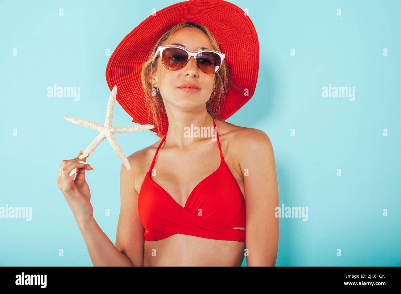 Pretty beautiful girl in red bra bikini, trendy sunglasses and short denim  shorts trying climb up a stone wall. Urban scene, city life. Cute attractiv  Stock Photo - Alamy