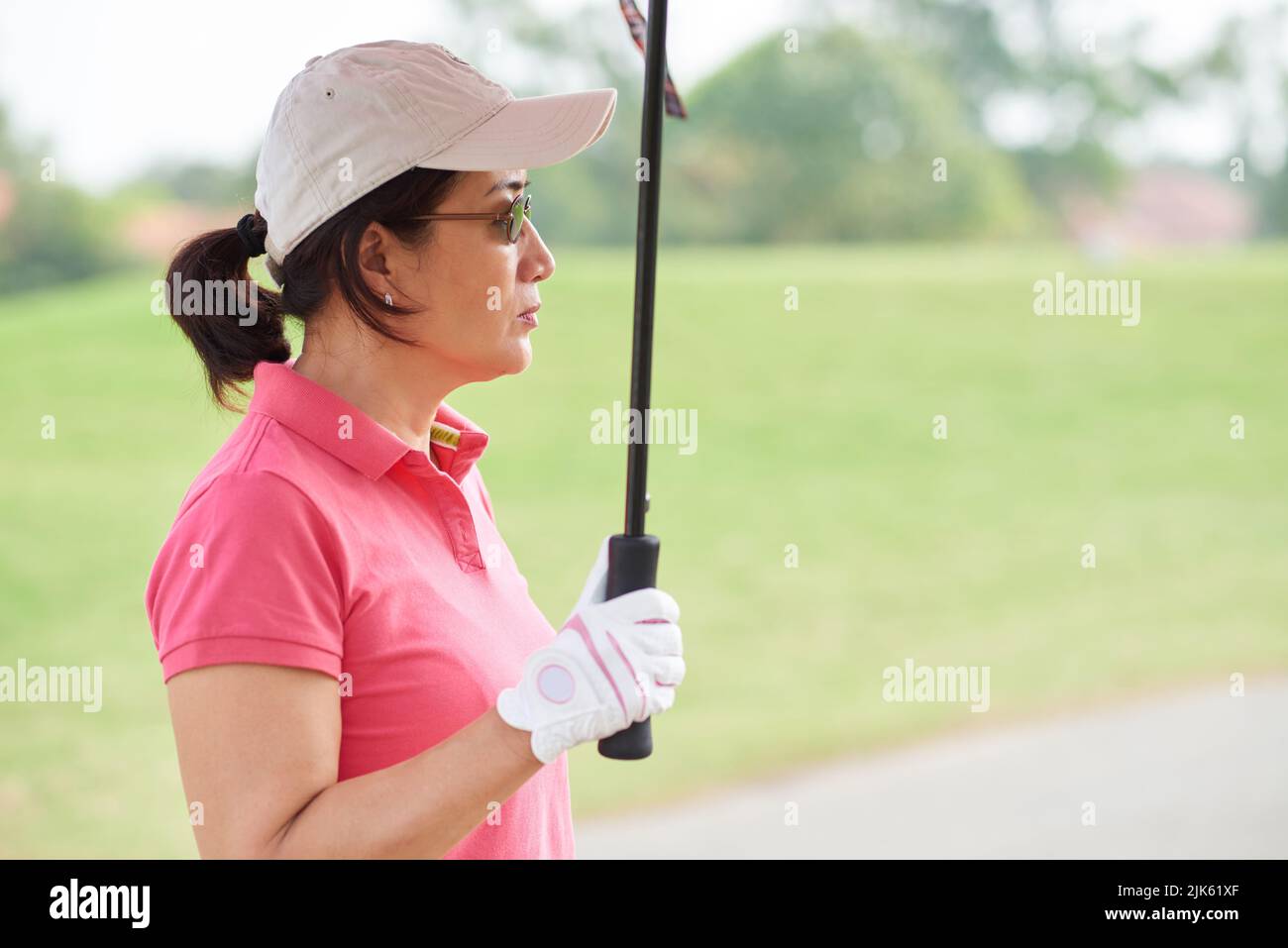Female professional golf player standing under umbrella Stock Photo Alamy