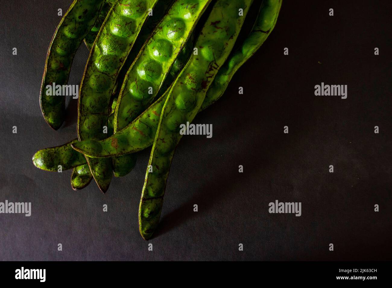 Petai, Twisted cluster bean, Stink bean, Bitter Bean, Parkia speciosa seeds, isolated on black background Stock Photo