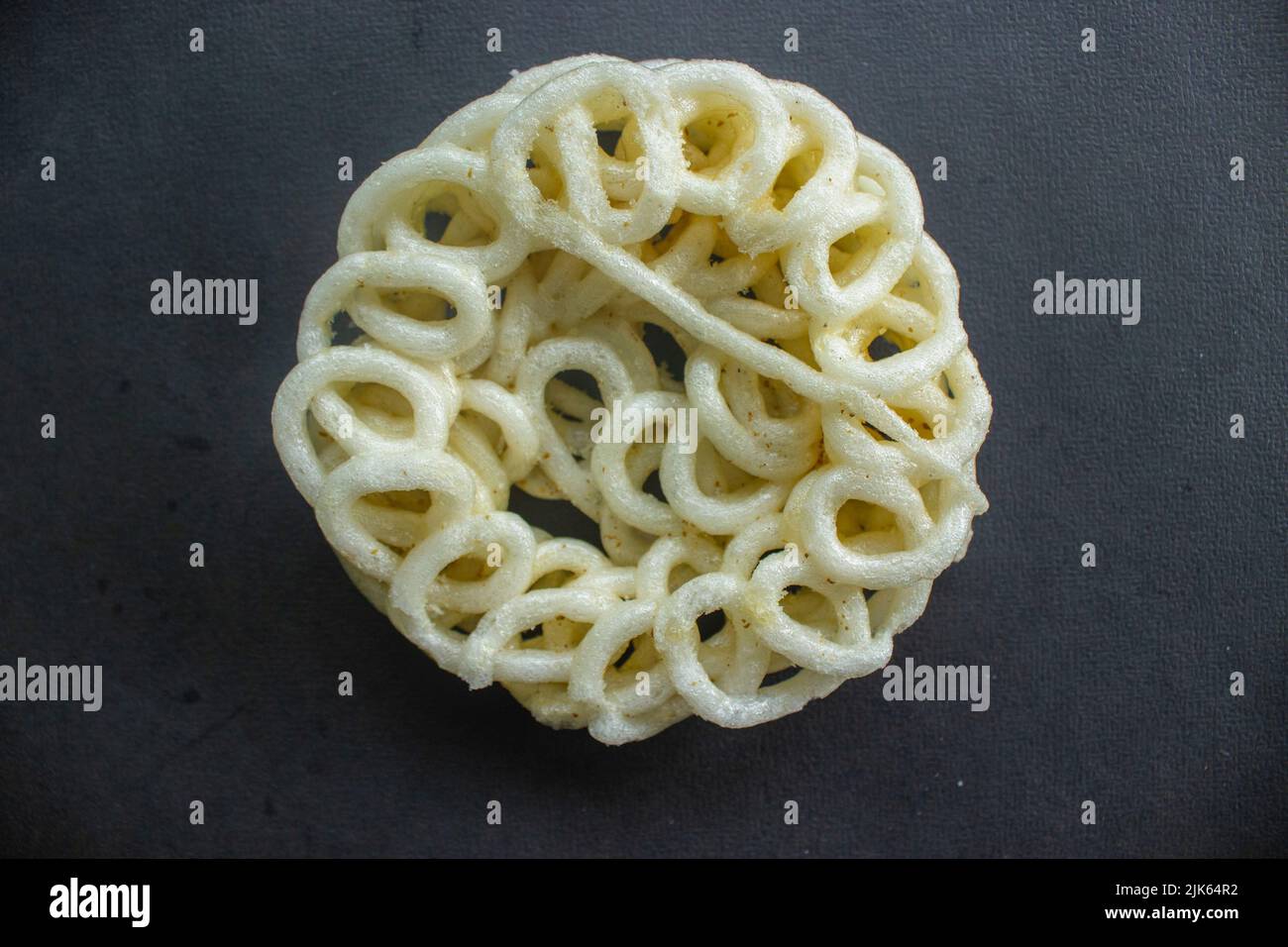 kerupuk or krupuk or crackers isolated on black background. kerupuk is snacks made from tapioca flour dough mixed with flavorings such as shrimp or fi Stock Photo