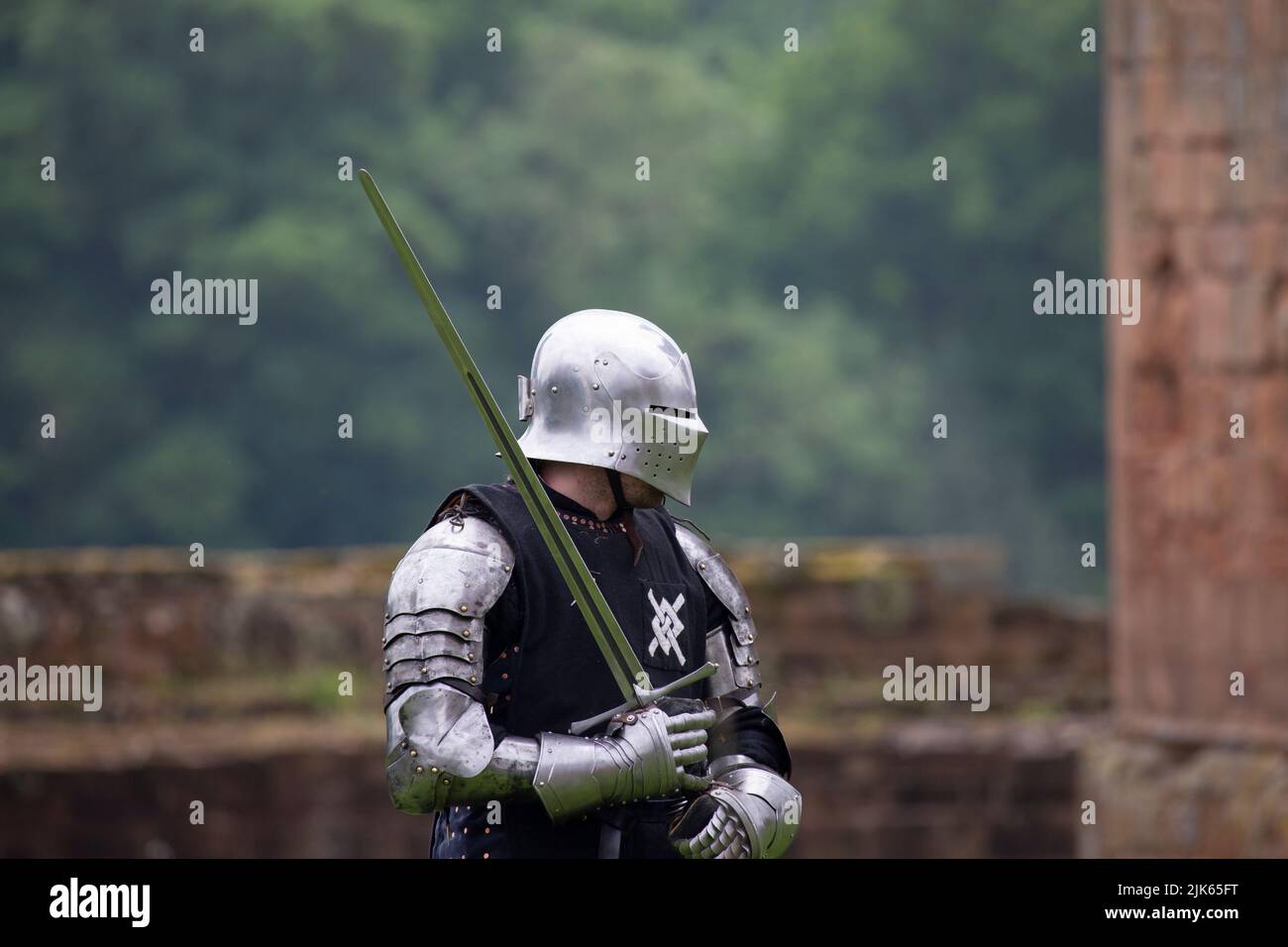 Knight in shining armor. Detail metal helmets. Medieval warrior with sword Stock Photo