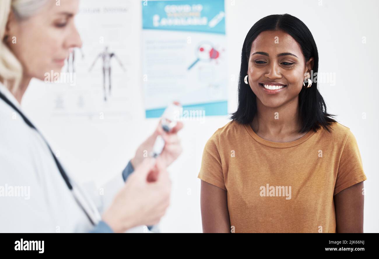 I cant wait to get my dose of protection. a doctor giving a patient an injection at a clinic. Stock Photo