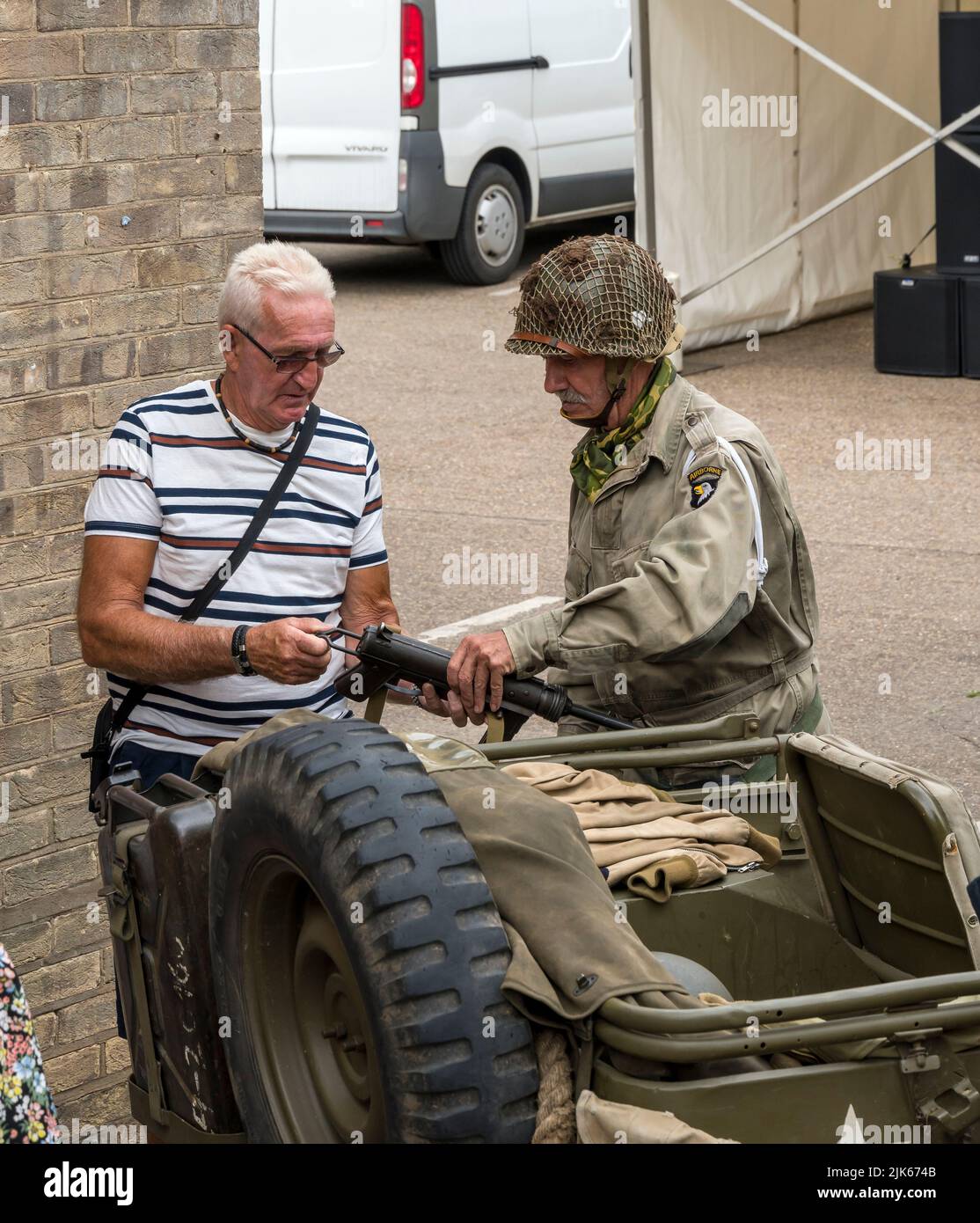 American airbourn soldier showing visitor his weapon Lincoln 1940's weekend, Lincoln Cathedral Quarter, 23rd July 2022 Stock Photo