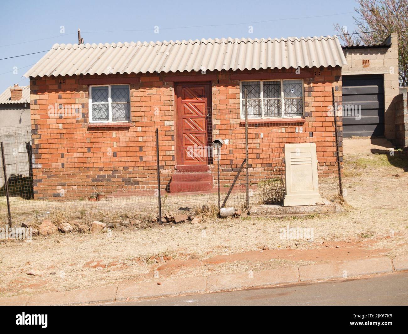 Simple architecture of small home on dusty street in Johannesburg South ...