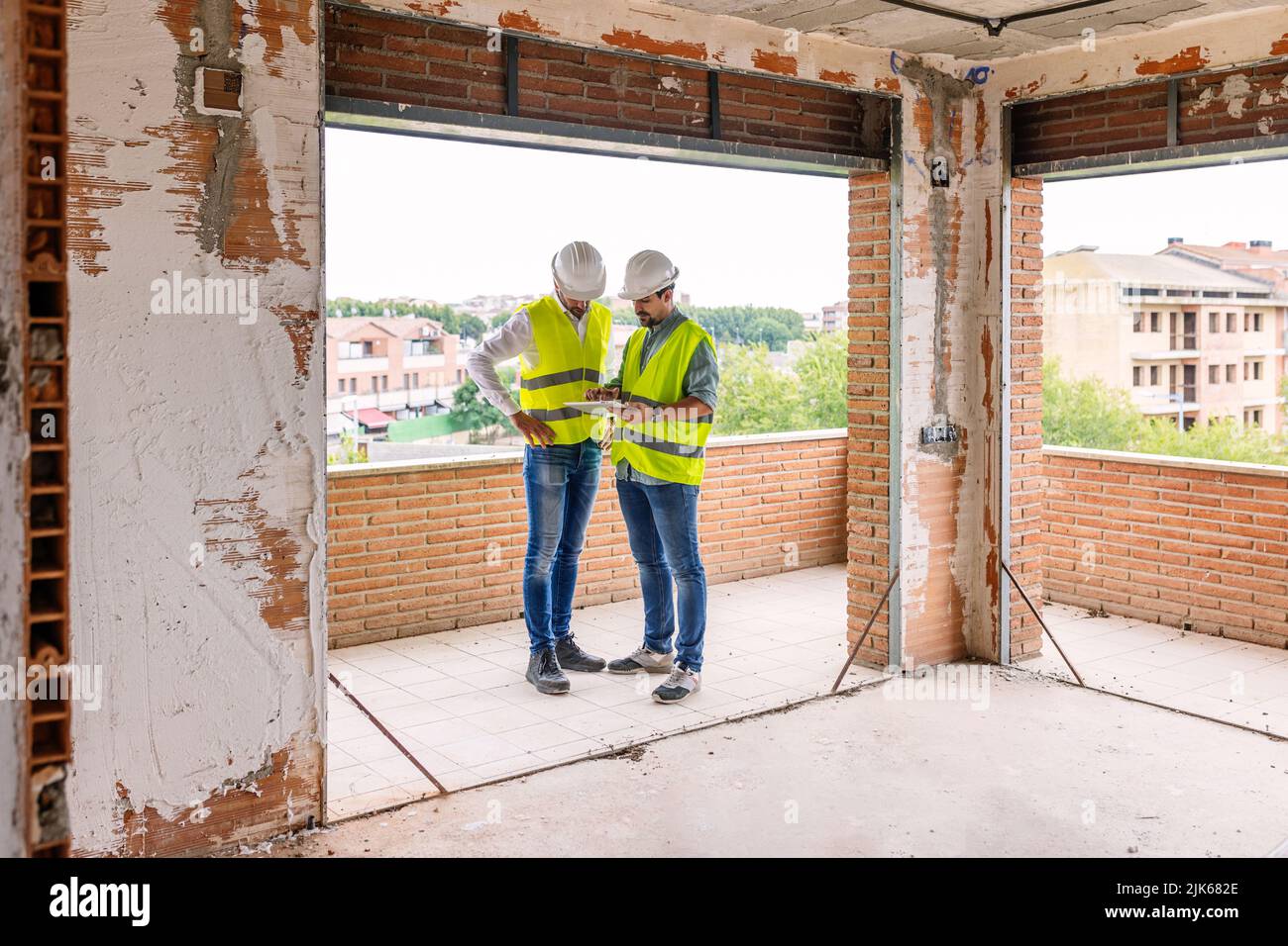 Two adult construction architect men working on digital tablet at building site Stock Photo