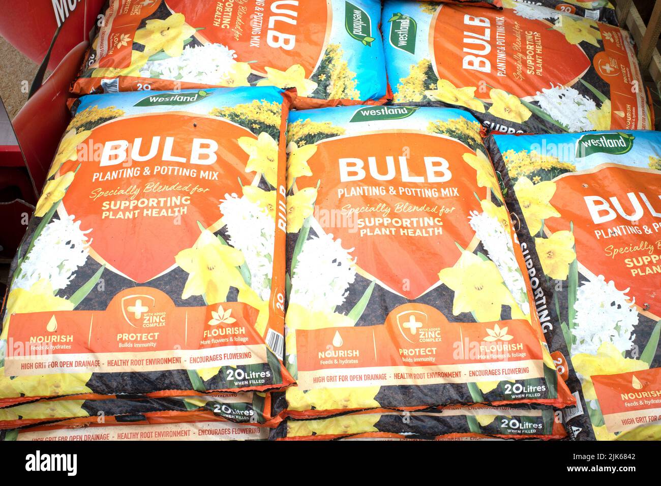 A stack of orange bags of Westland bulb planting and potting mix  in a garden centre Stock Photo
