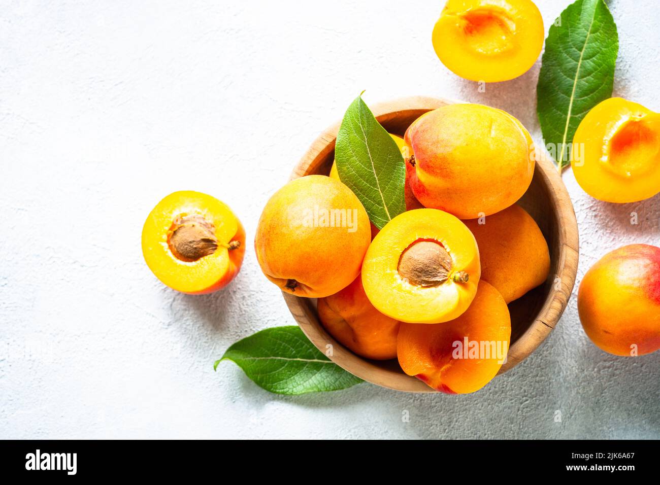 Fresh apricots with green leaves at white. Stock Photo