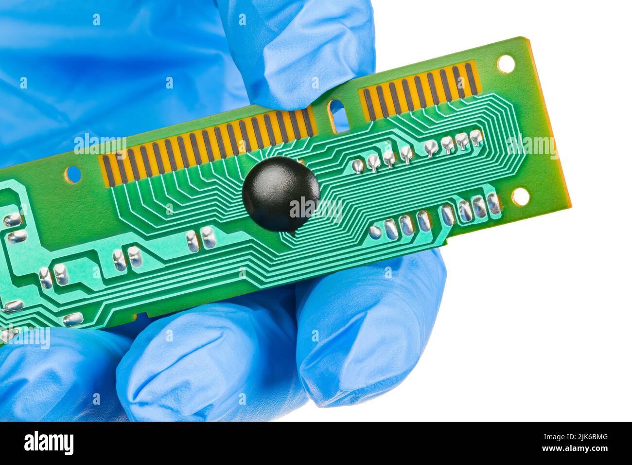 Closeup of electronic chip on board in engineer gloved hand isolated on white background. Black epoxy blob of integrated circuit cover embedded to PCB. Stock Photo