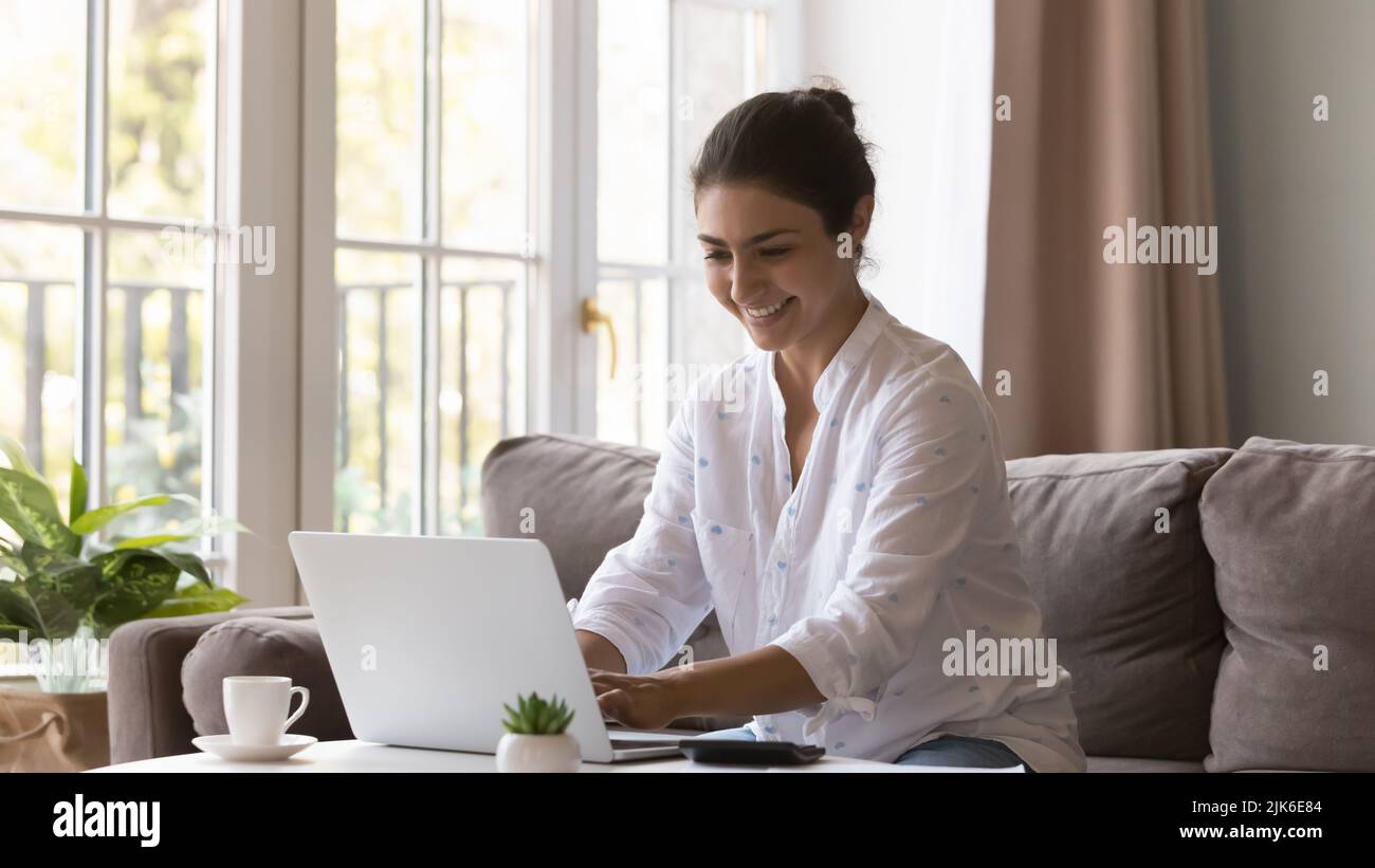 Happy Indian freelancer woman working from home, using laptop Stock Photo