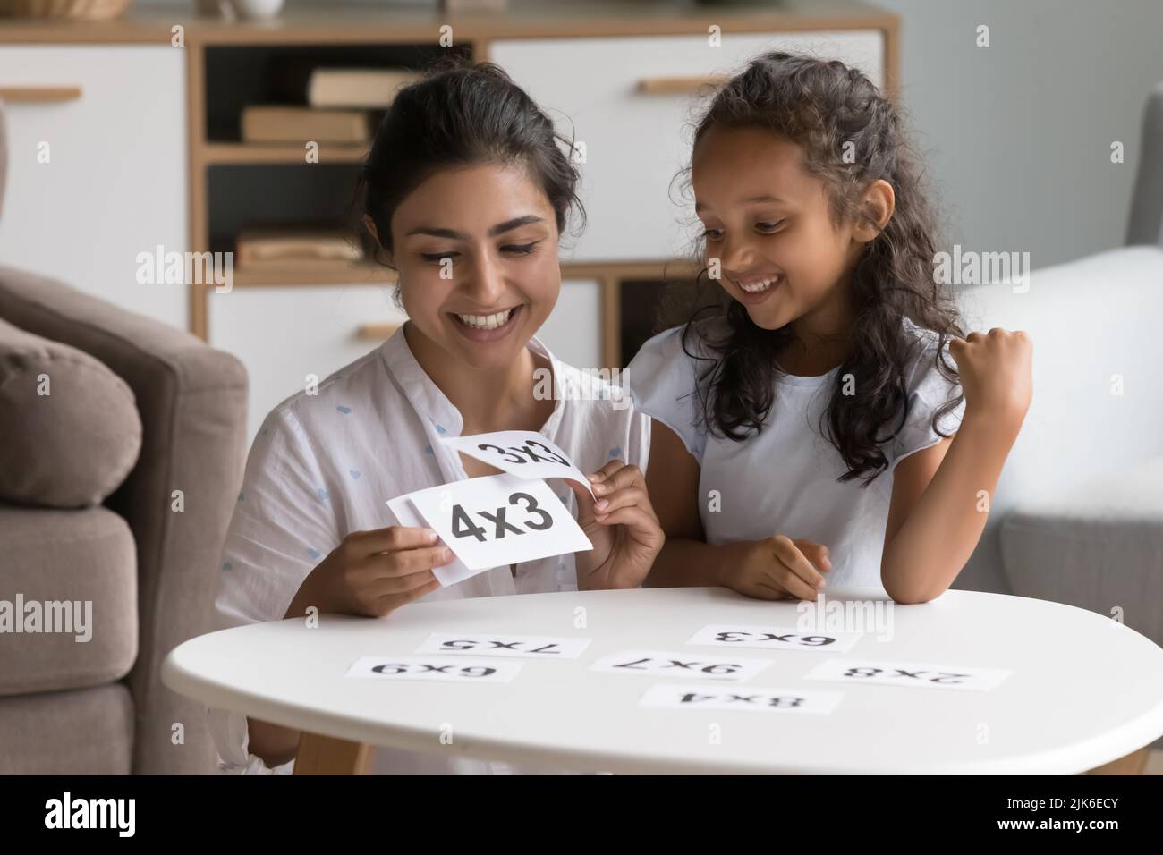 Happy Indian daycare teacher showing flash cards to little kid Stock Photo