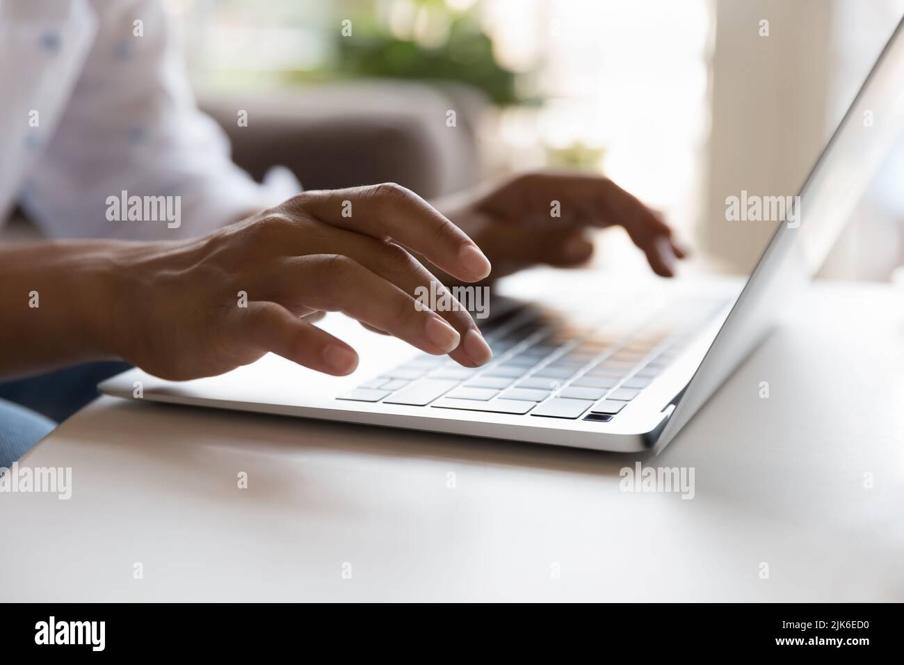 Young laptop user woman using computer, typing on keyboard Stock Photo