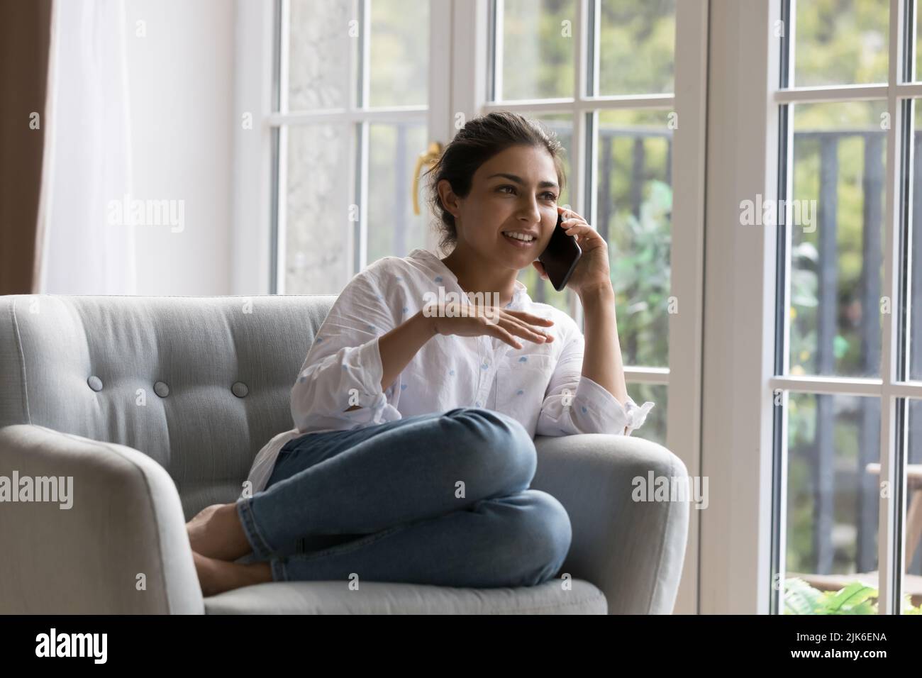 Happy beautiful millennial Indian woman talking on mobile phone call ...