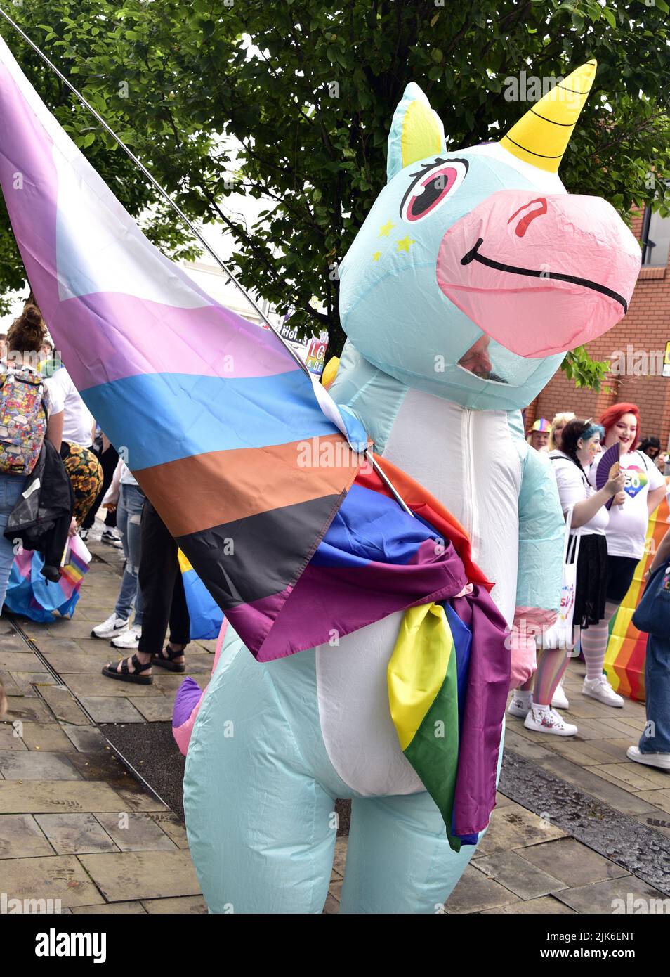 Stockport, UK, 31st July, 2022. A person in an inflatable unicorn costume carries a Freedom flag. Stockport LGBTQ+ Pride Parade in Stockport, Greater Manchester, England, United Kingdom, British Isles. Organisers say the parade is: 'Celebrating Stockport's LGBTQ+'. Community'. The parade marched from Bridgefield Street to Stockport's historic Market Place. Credit: Terry Waller/Alamy Live News Stock Photo