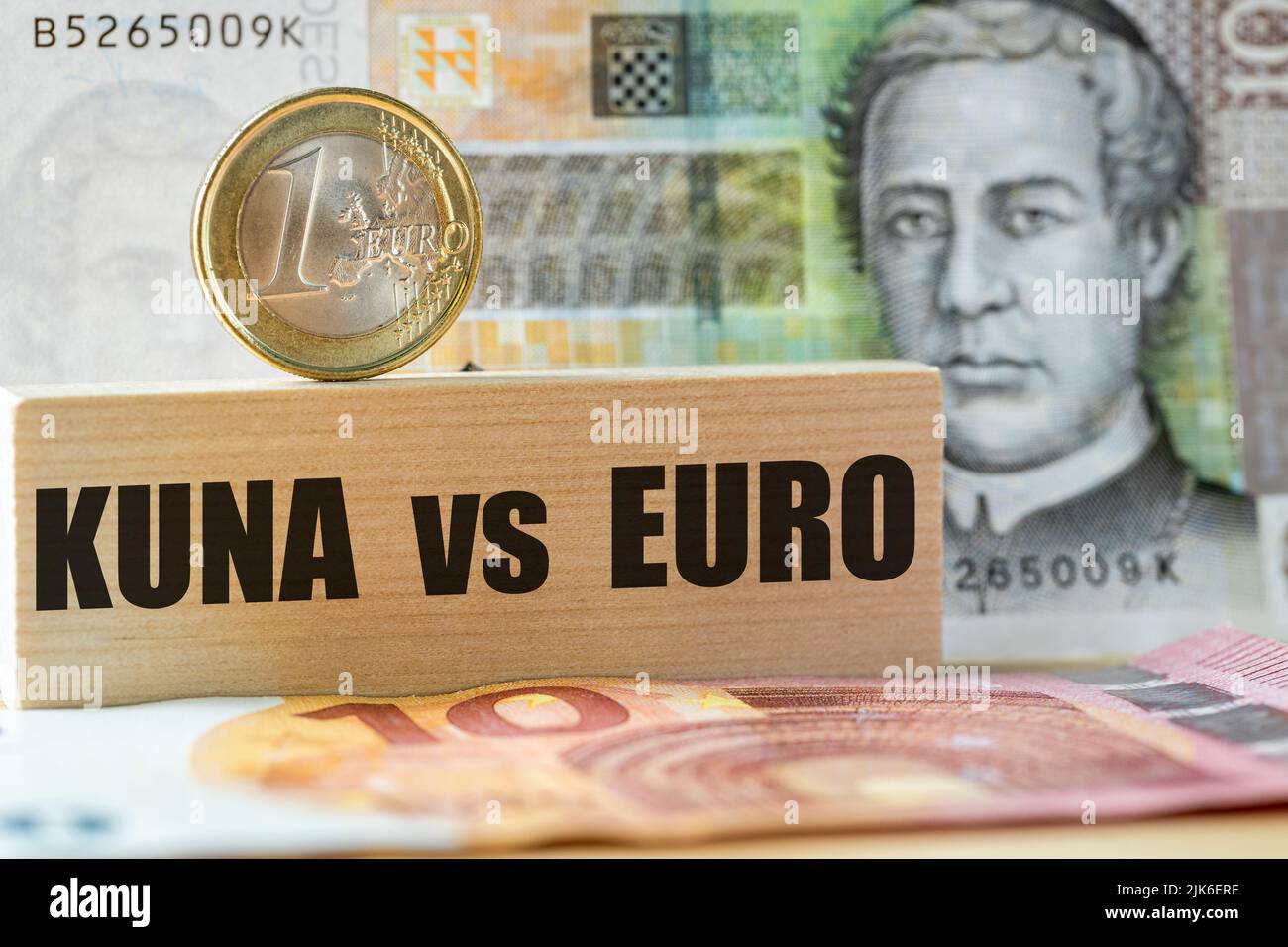 10 kuna banknote, 1 euro coin on a wooden block, written Kuna vs Euro, Concept, Croatian currency exchange into euro, Croatia's entry into the Euro zo Stock Photo