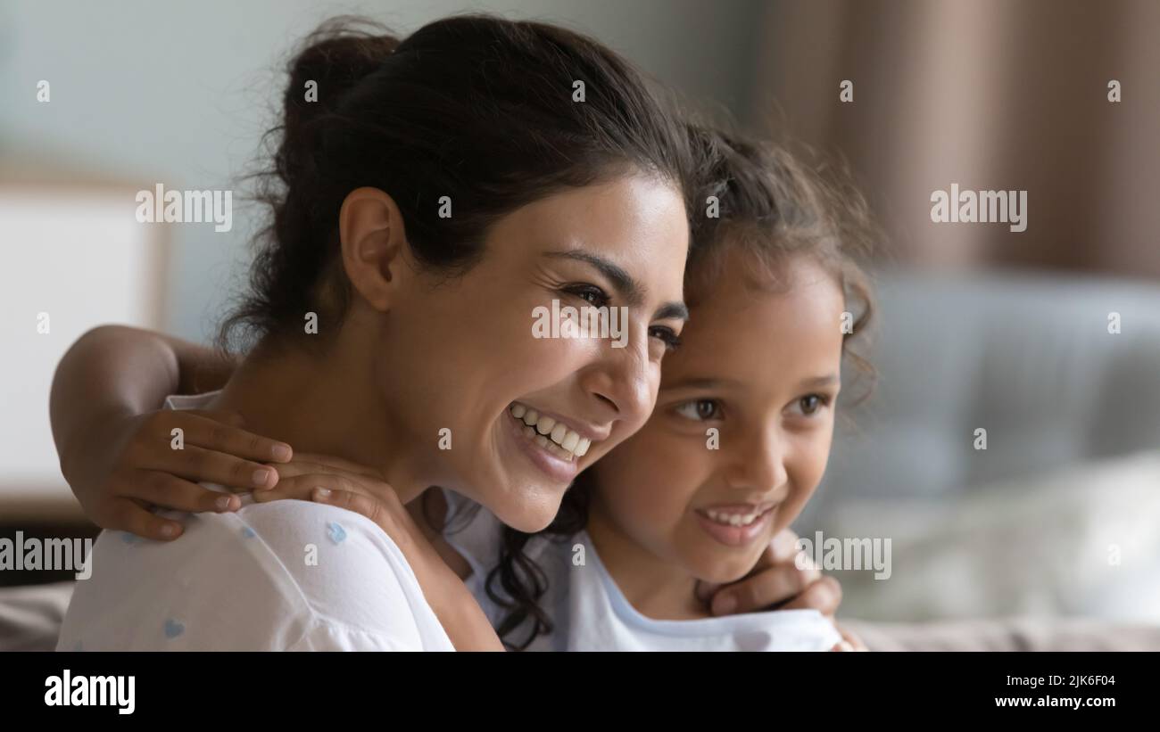 Joyful young Indian mother hugging happy little girl Stock Photo