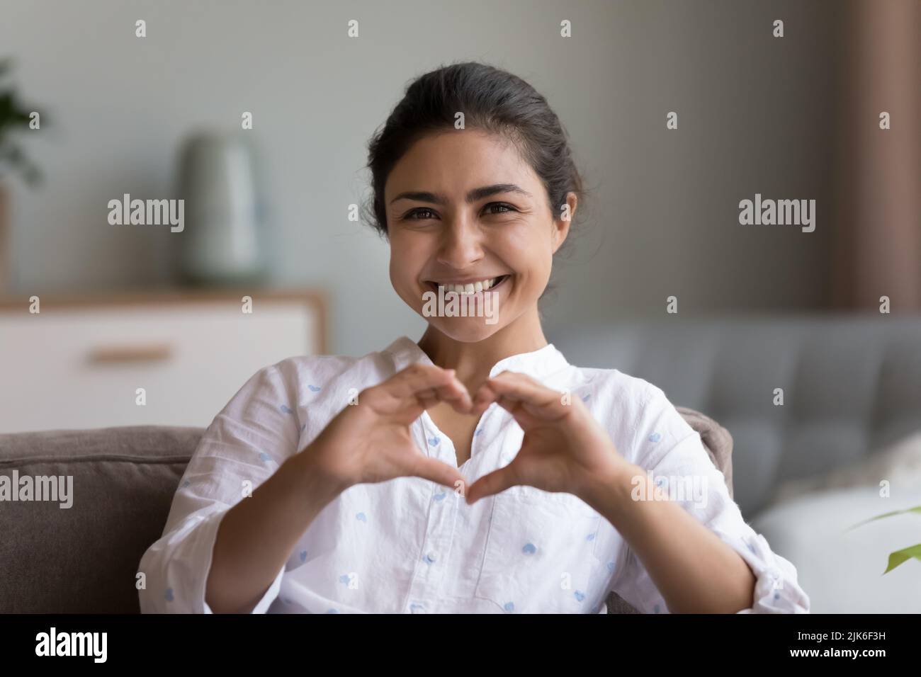 Happy pretty young Indian woman showing joined hands at chest Stock Photo