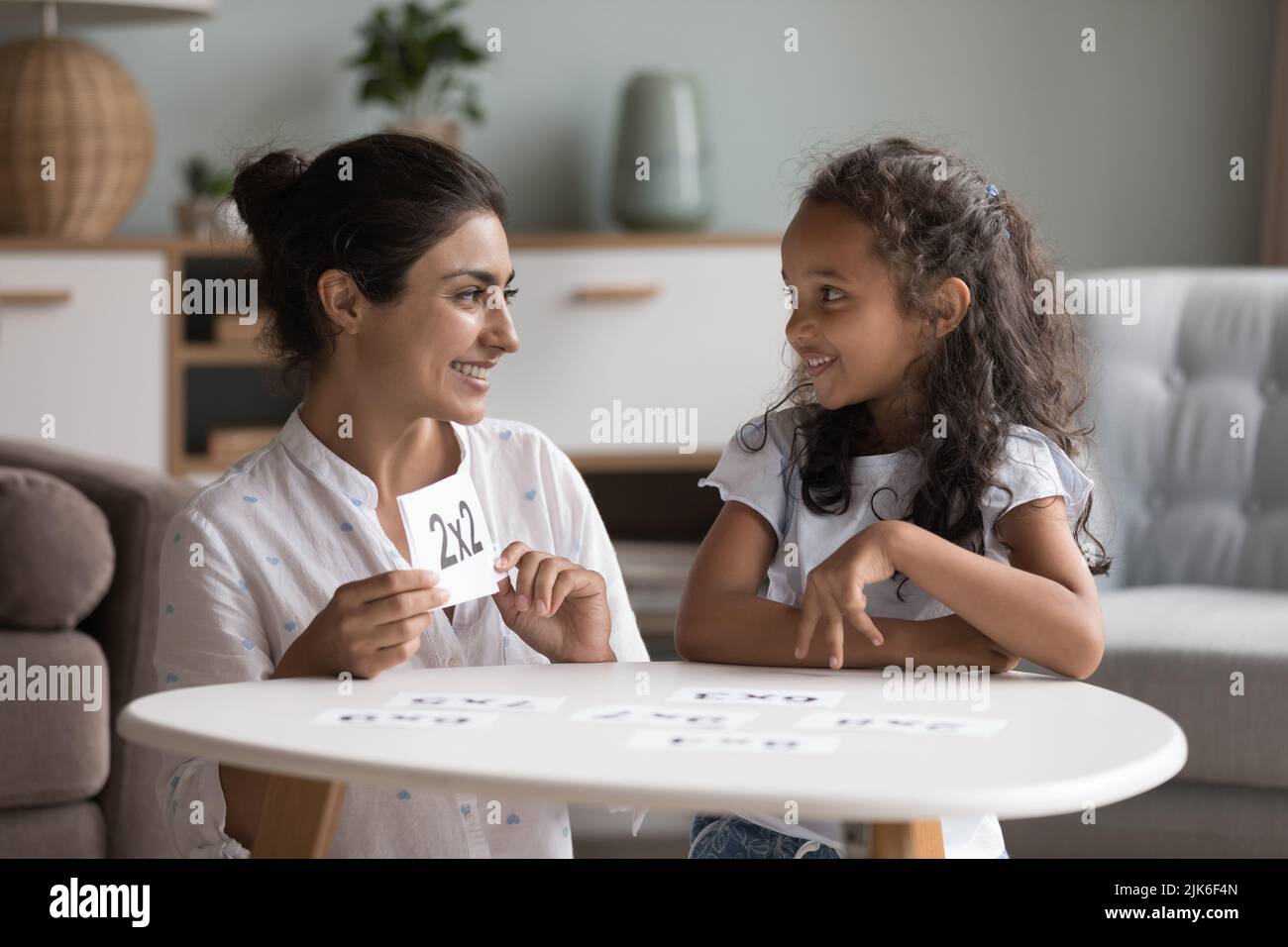Happy Indian mom helping kid to study math Stock Photo