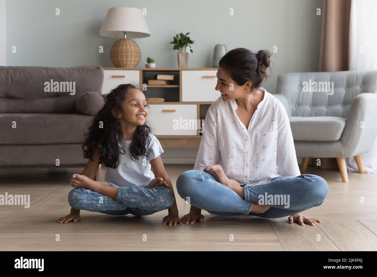 Happy Indian mom and daughter doing yoga together at home Stock Photo