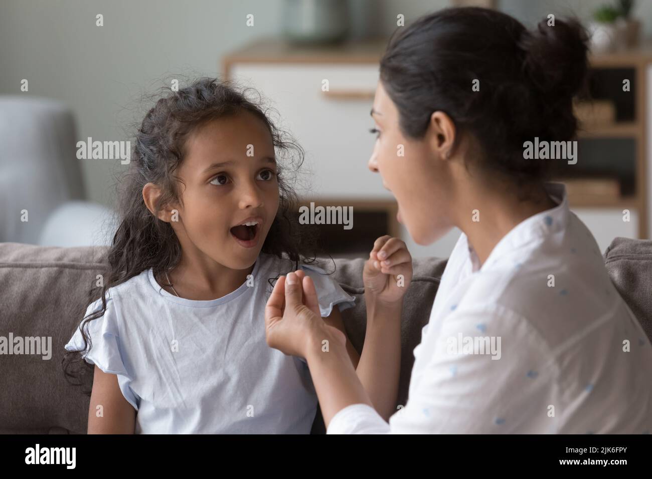 Indian female therapist training kid with hearing disability Stock Photo