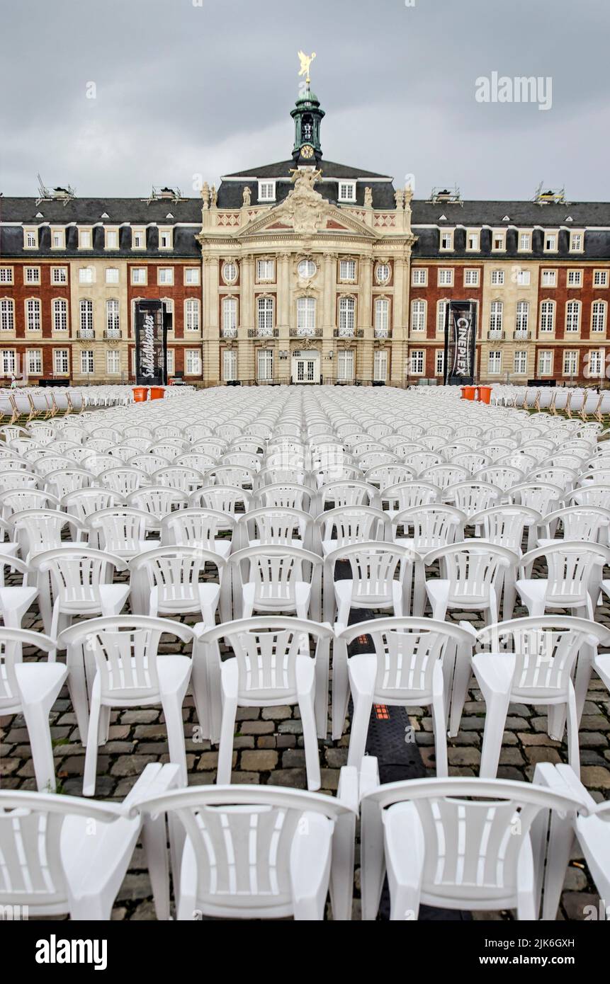 Münster, Germany, July 29, 2022: hundreds of white plastic chairs placed in front of the Schloss for the open air summer cinema Stock Photo