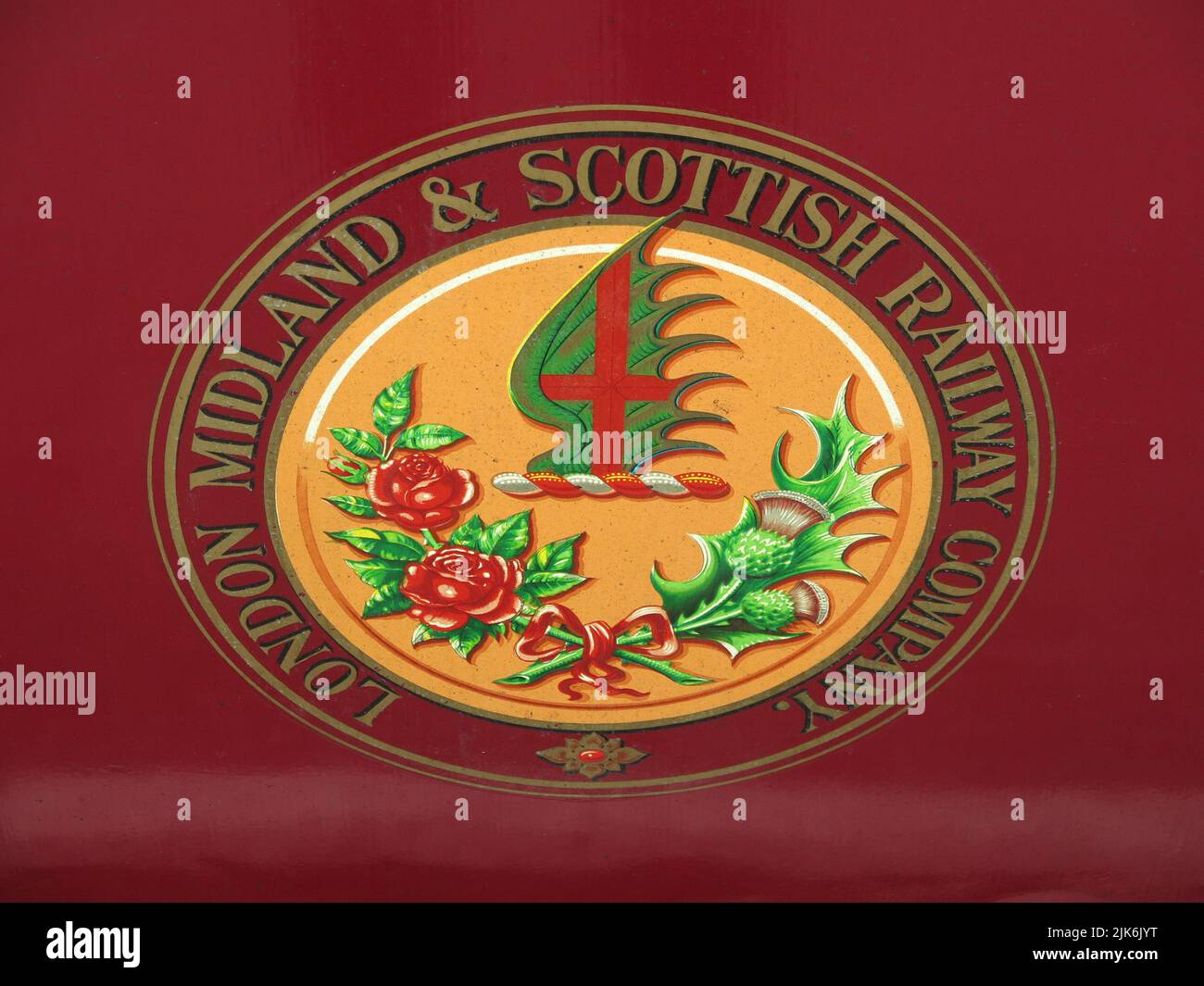 Close-up of the red livery and logo of the London Midland & Scottish Railway Company on a train carriage on the Strathspey Heritage Steam Railway. Stock Photo