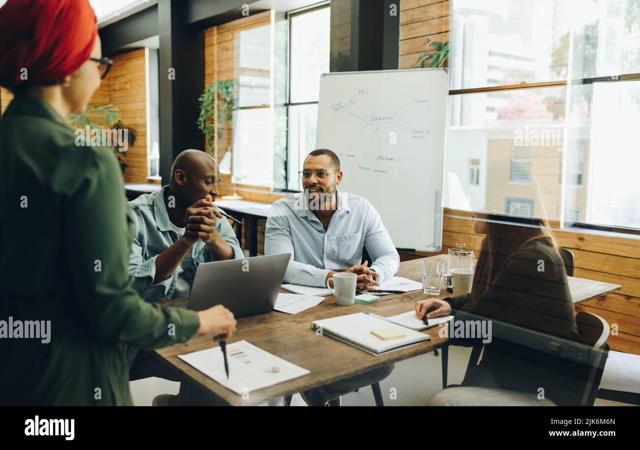 Creative business team sharing ideas during a boardroom meeting. Group of multicultural business professionals having a discussion in an inclusive wor Stock Photo