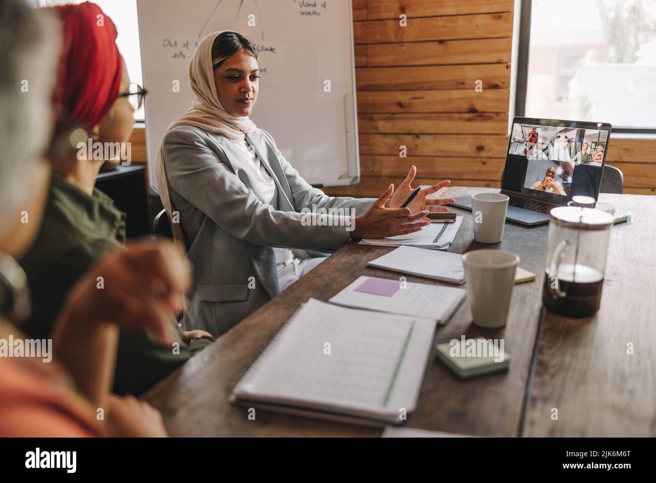 Muslim businesswoman leading a discussion during an online meeting in a creative office. Group of multicultural businesswomen having a video conferenc Stock Photo