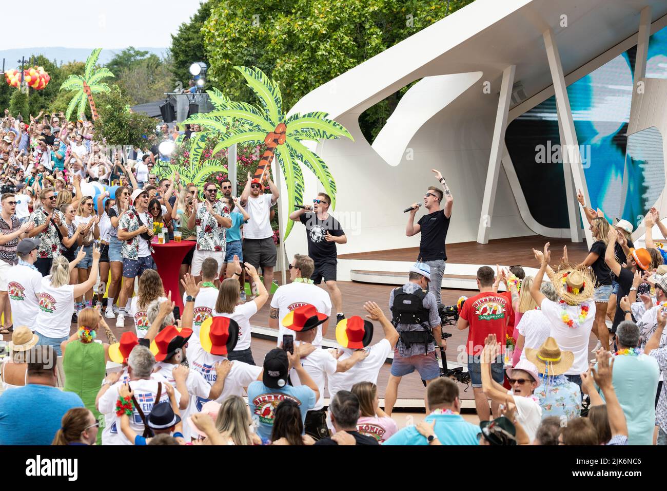 Mainz, Germany. 31st July, 2022. The audience celebrates the performance of the hit duo DJ Robin & Schürze with the controversial song 'Layla' in the 'ZDF-Fernsehgarten'. For weeks there has been a sexism debate about their song. On Sunday, 'Fernsehgarten' had the party motto 'Mallorca vs. Oktoberfest. Credit: Hannes P. Albert/dpa/Alamy Live News Stock Photo