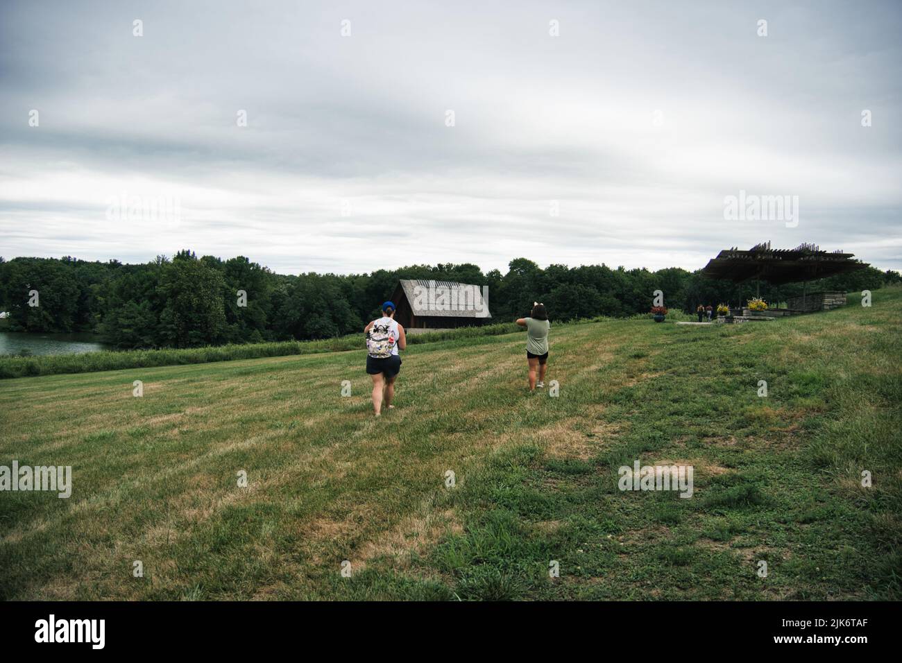 Rural scene of a mother and daughter walking toward a remote chapel in Kingsville Missouri Stock Photo