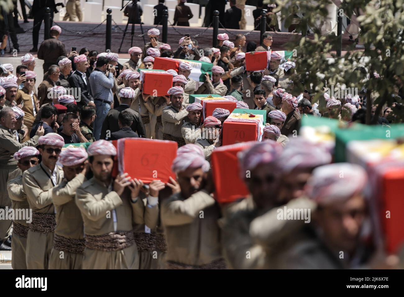 Barzan, Iraq. 31st July, 2022. Kurdish men carry coffins containing the