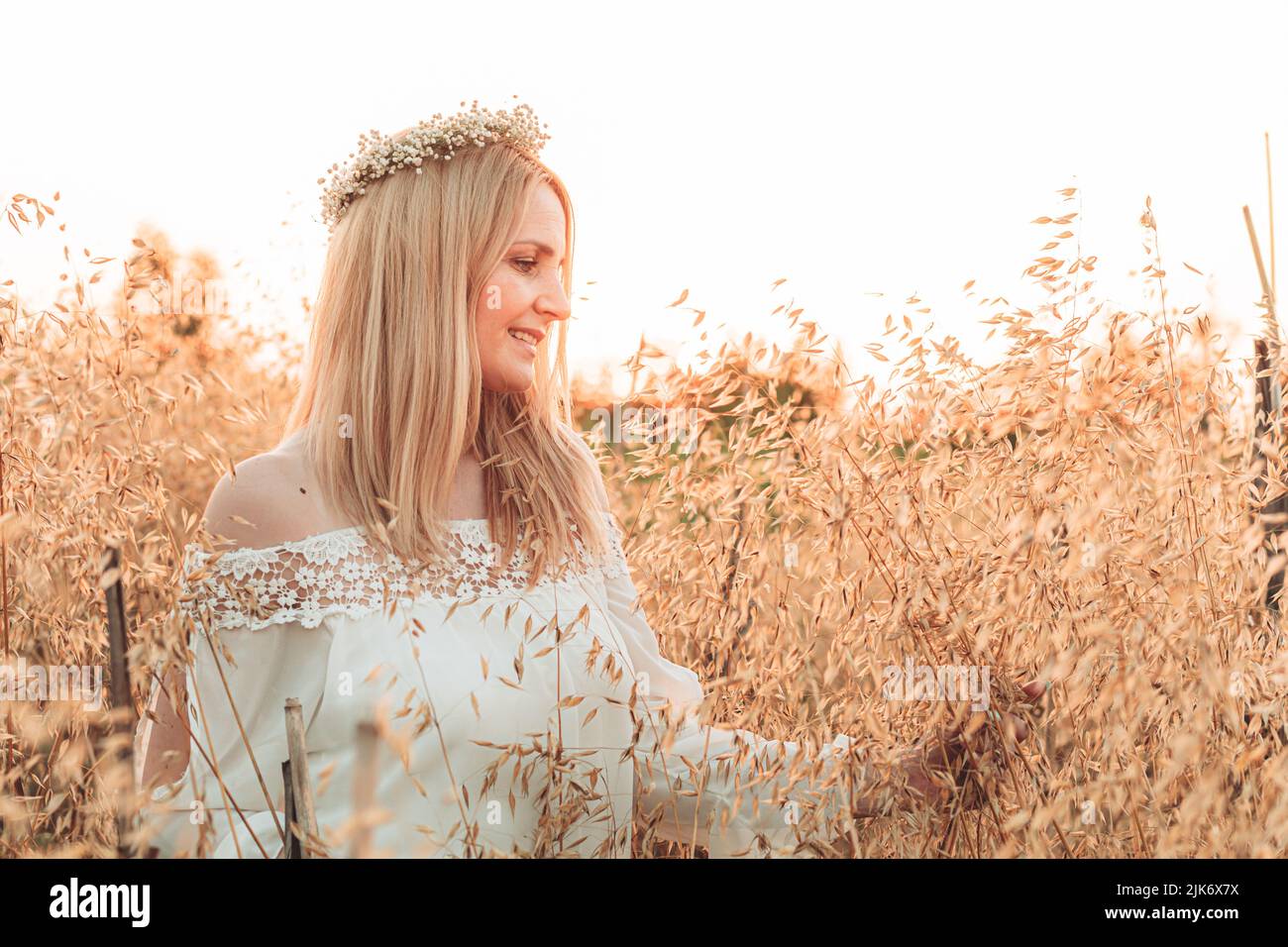 Young, blonde woman standing in the wheat field Stock Photo - Alamy