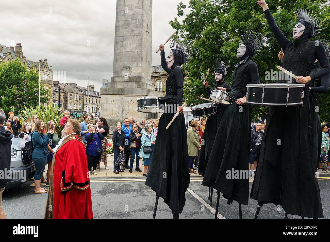 The Mayor of Harrogate, Victoria Oldham, is wearing a traditional red robe as she leads stilt drummers in the Harrogate Carnival Parade in North Yorks Stock Photo